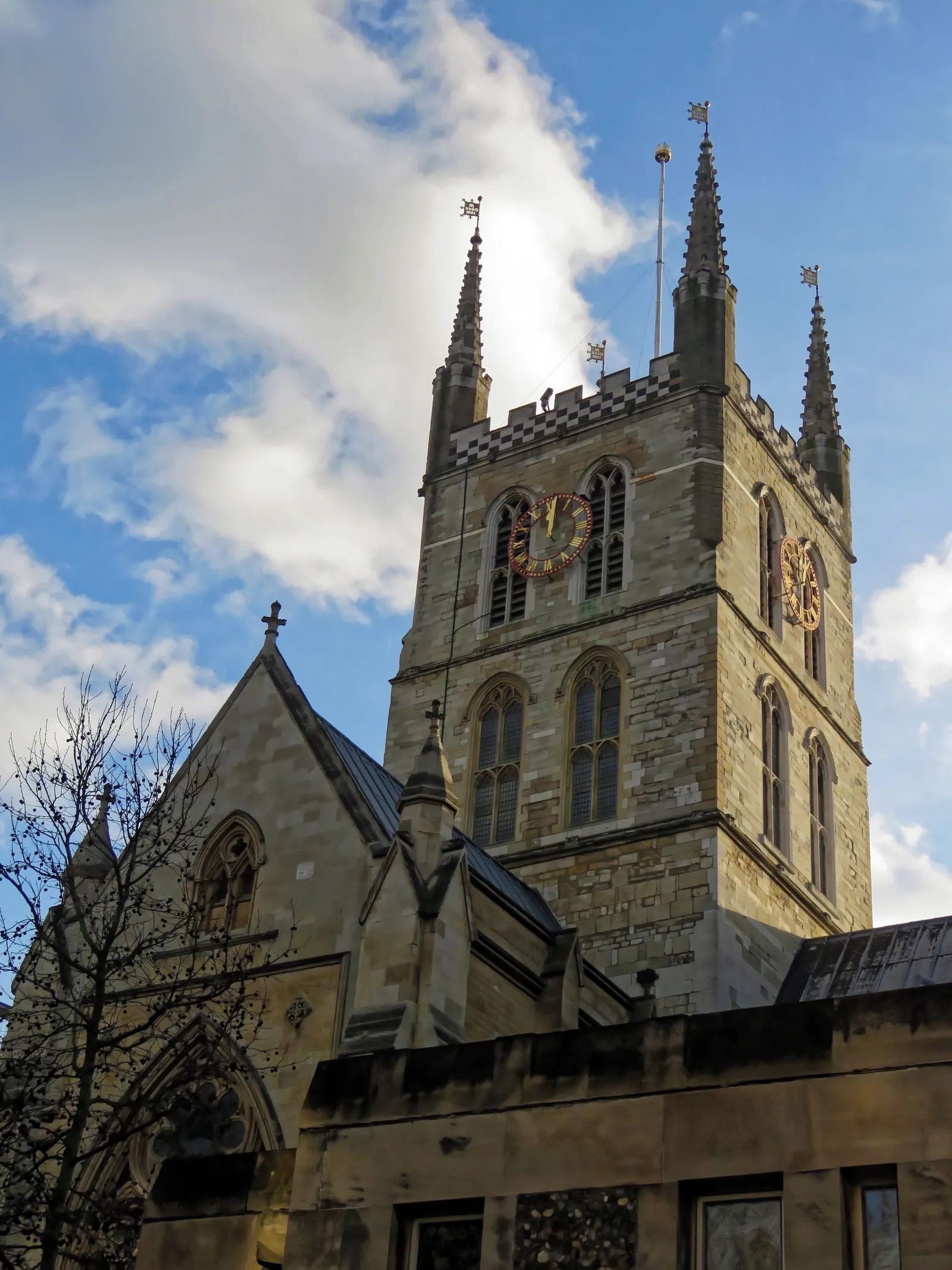 The Gothic bell tower of Southwark Cathedral against a blue sky