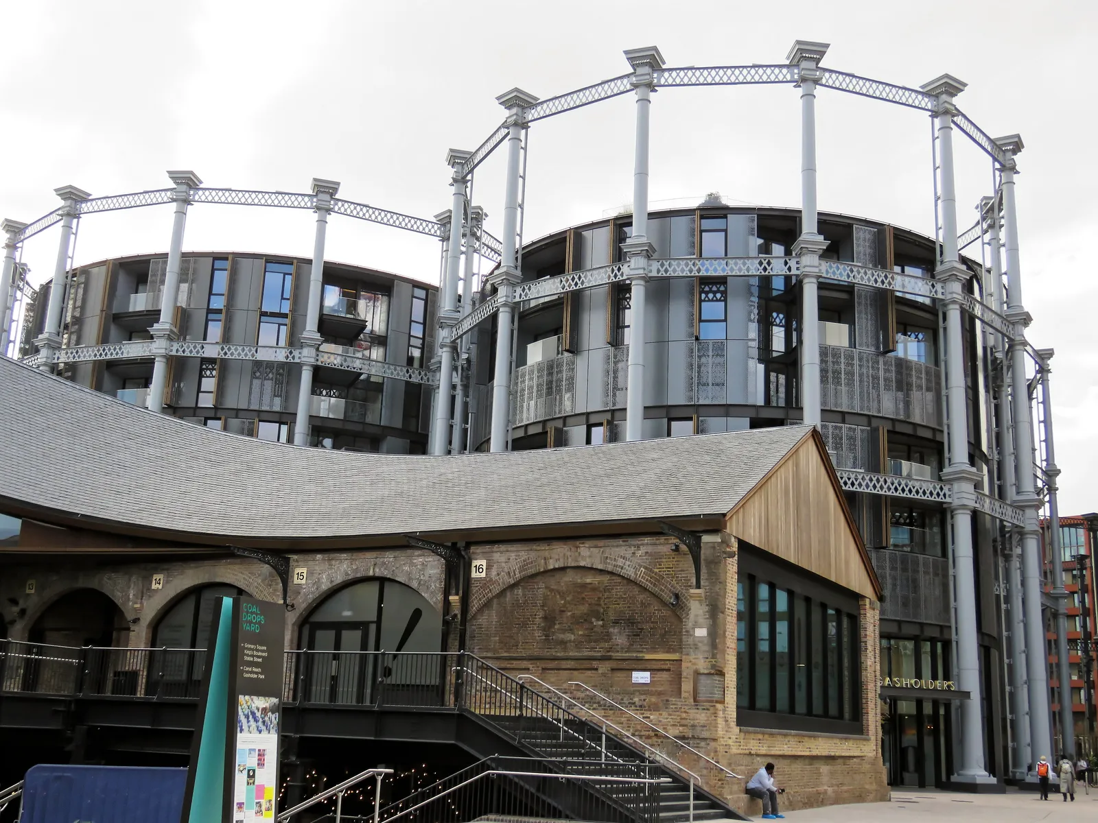 The undulating roofline of Coal Drops Yard beneath the restored Victorian gasholder apartments at King's Cross