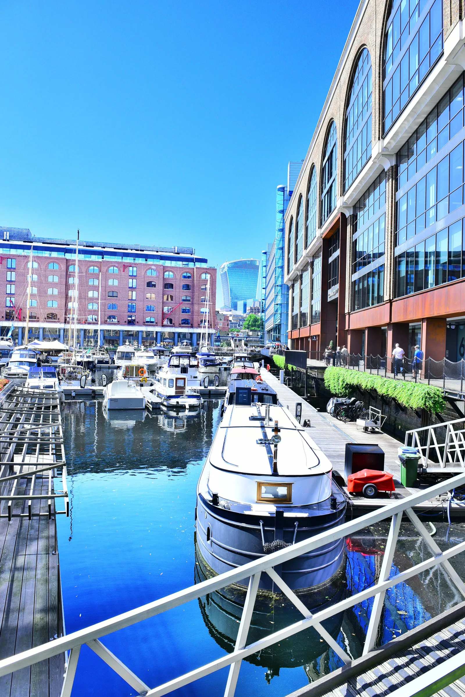 Boats moored in the marina at St Katharine Docks, with converted warehouse buildings alongside