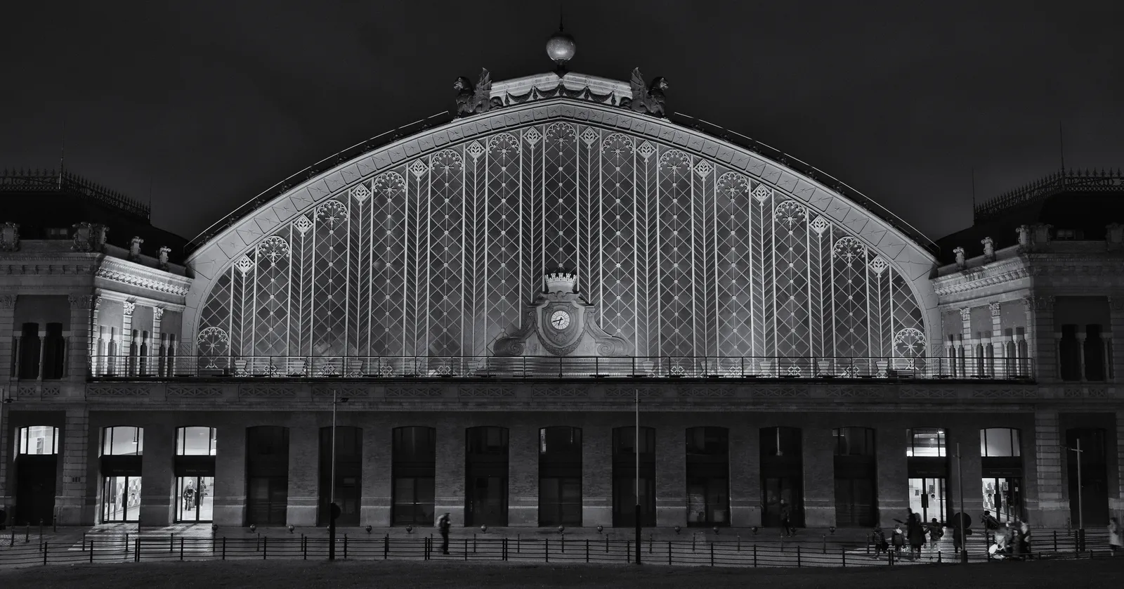 The large arched facade of Madrid Atocha station lit at night