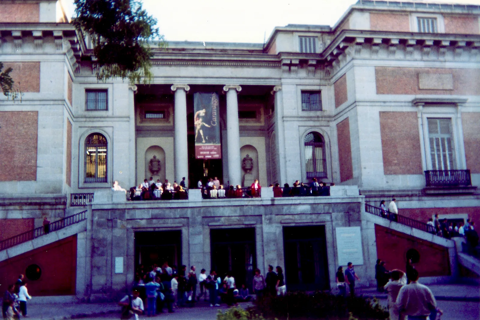 The neoclassical facade of the Prado Museum in Madrid with visitors gathered outside