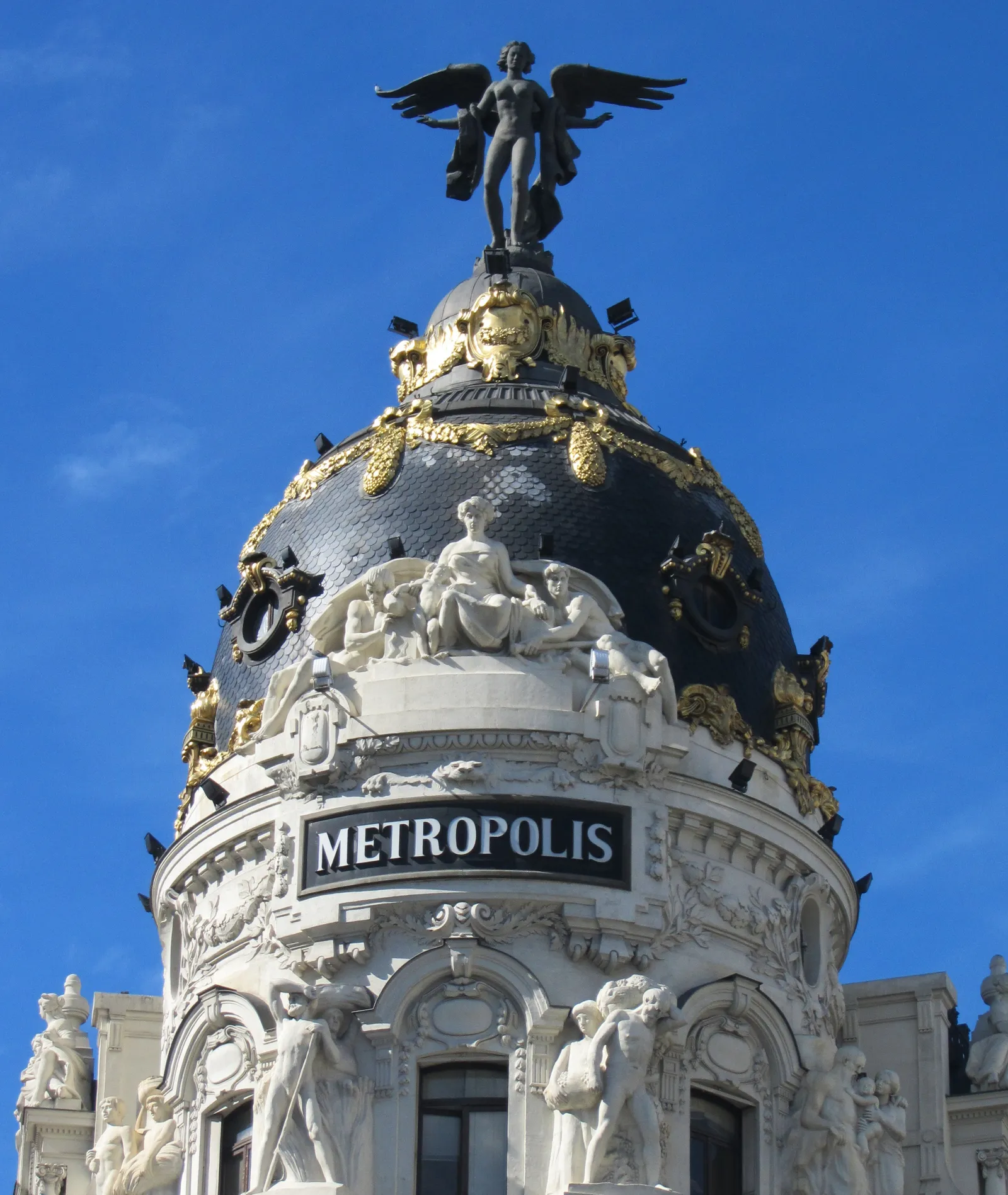 The black dome and winged statue atop Madrid's Metropolis Building on Gran Vía