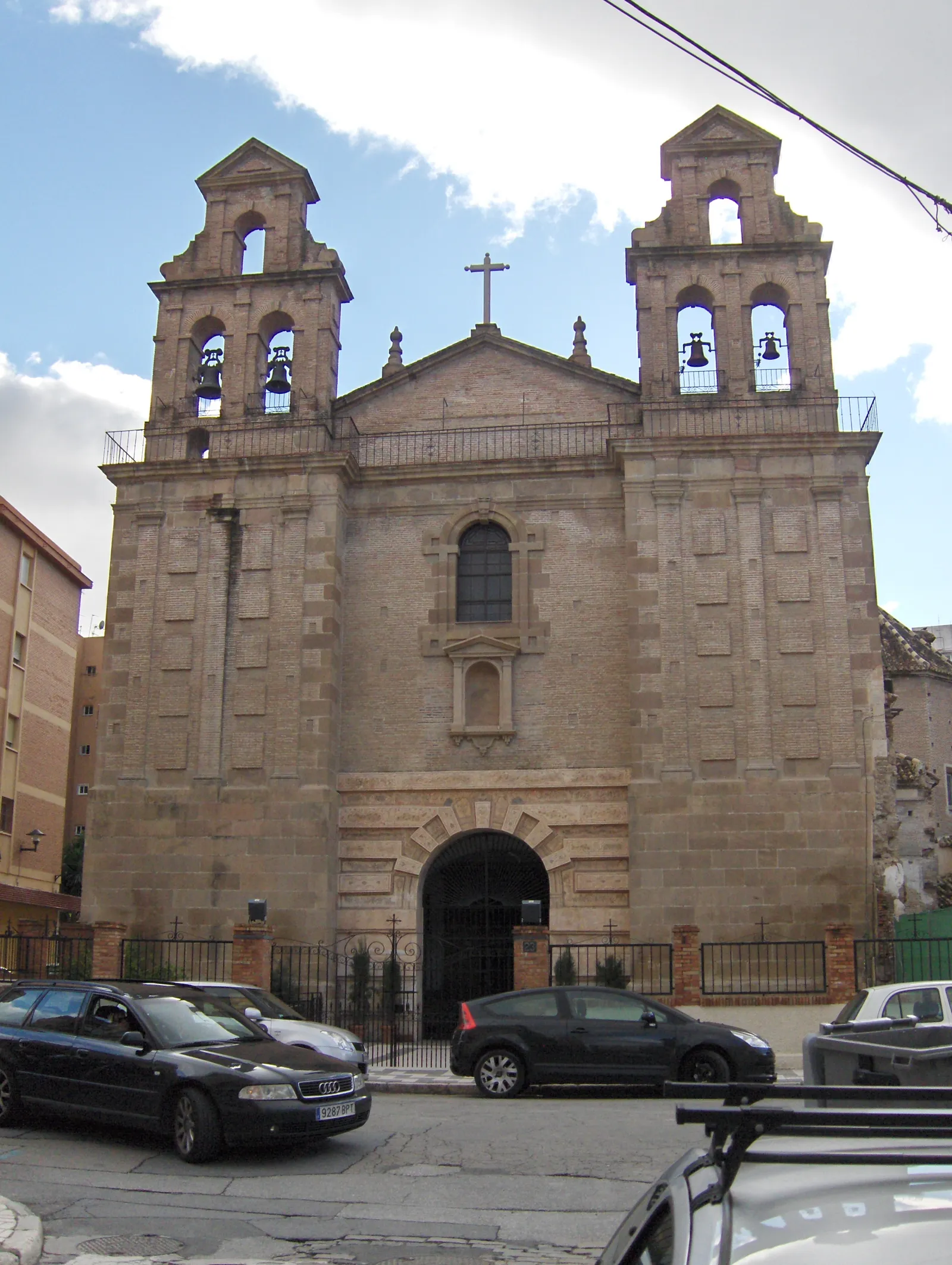 The Baroque twin-towered facade of Iglesia del Carmen in Málaga's El Perchel neighborhood, with bells visible in each tower