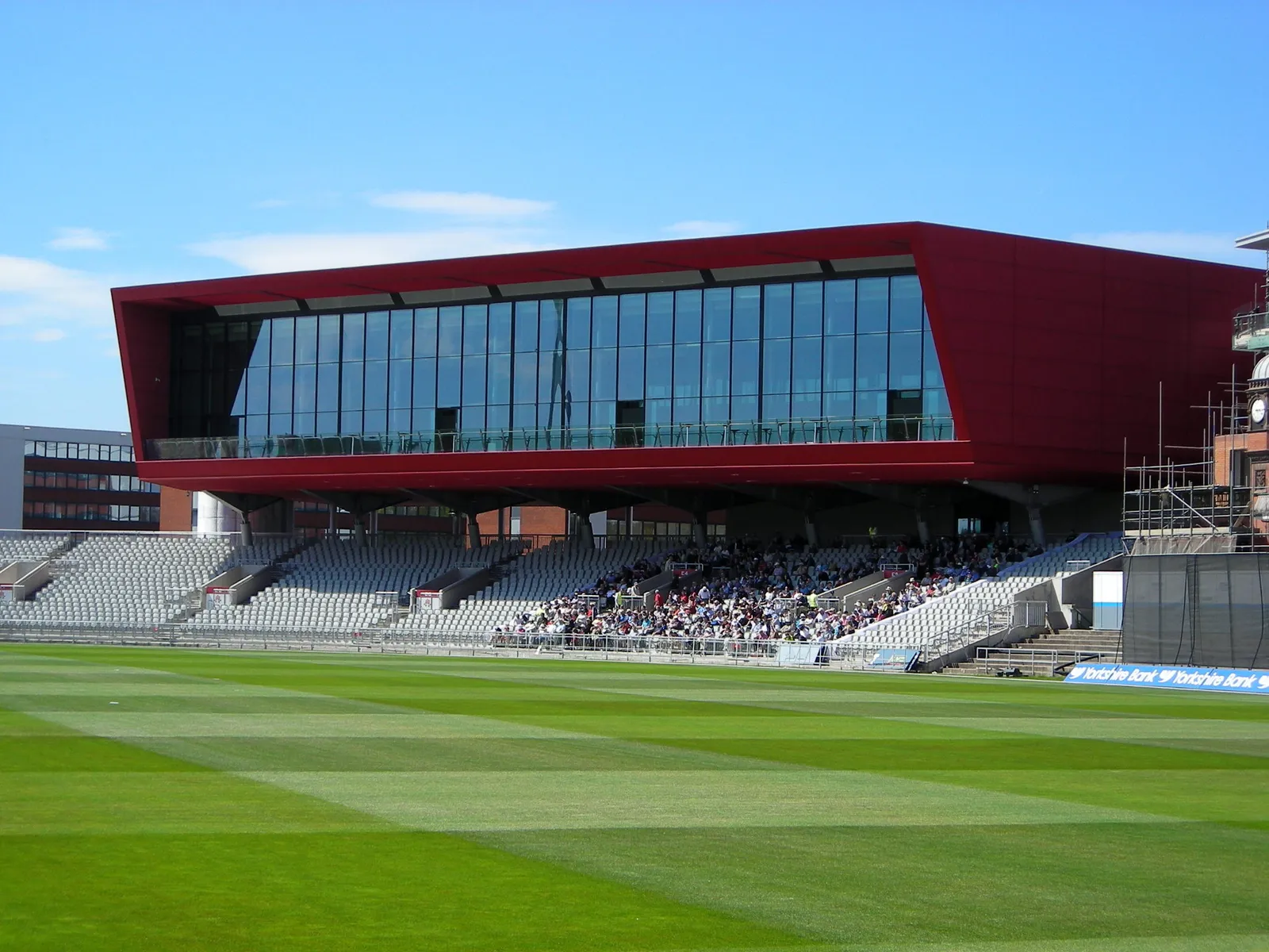 The Point, a modern red-clad pavilion building overlooking the pitch at Emirates Old Trafford cricket ground in Manchester