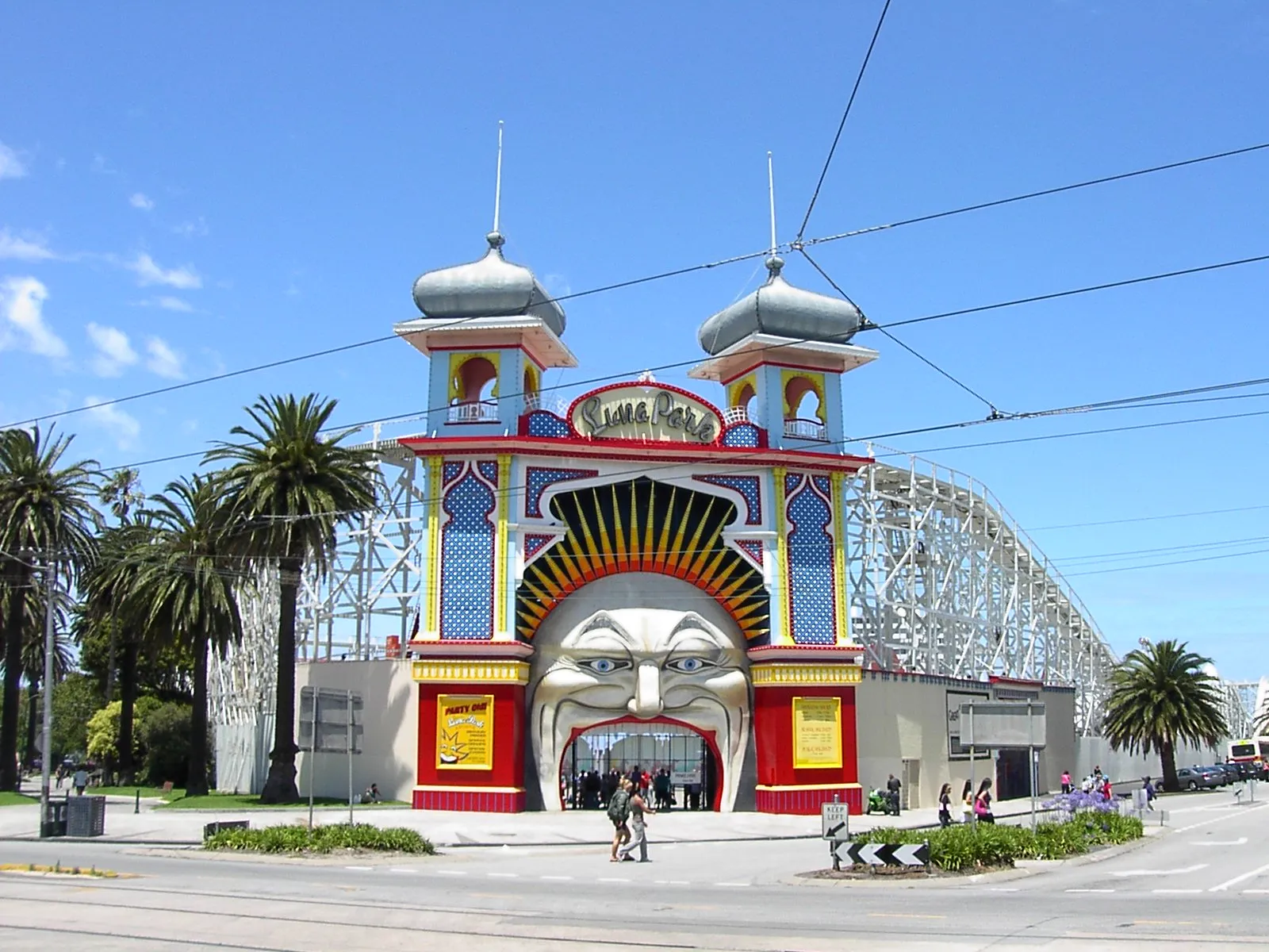 The Mr Moon face entrance to Luna Park in St Kilda, a huge painted laughing face between two onion-domed towers, with the timber roller coaster structure behind it
