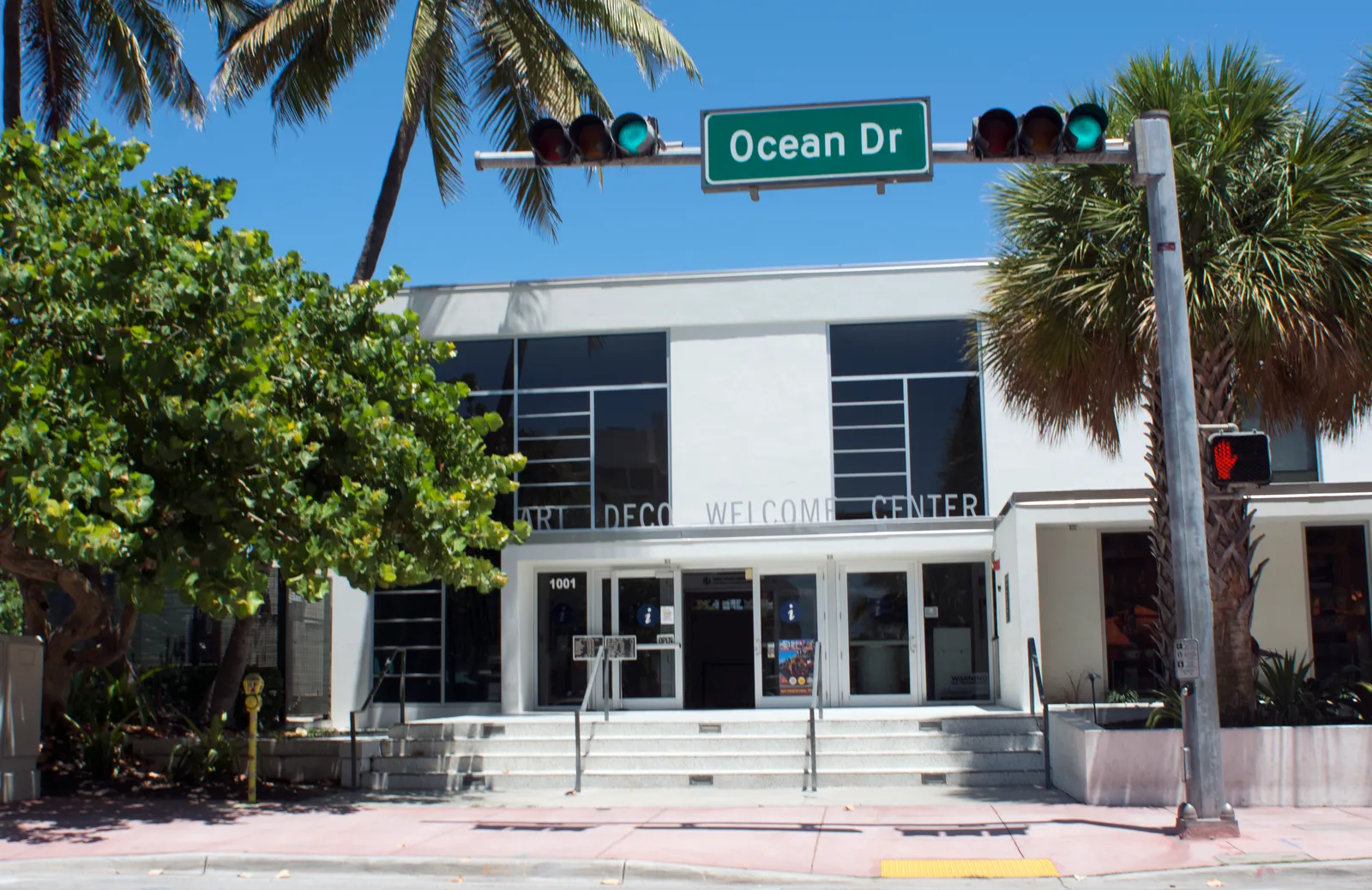 The Art Deco Welcome Center at 1001 Ocean Drive, with a street sign reading Ocean Dr out front