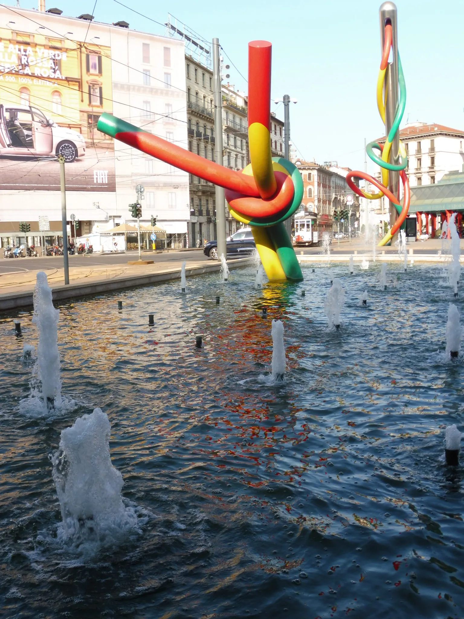 The colorful Ago, Filo e Nodo (Needle, Thread and Knot) sculpture rising from the fountain in Piazzale Cadorna, Milan