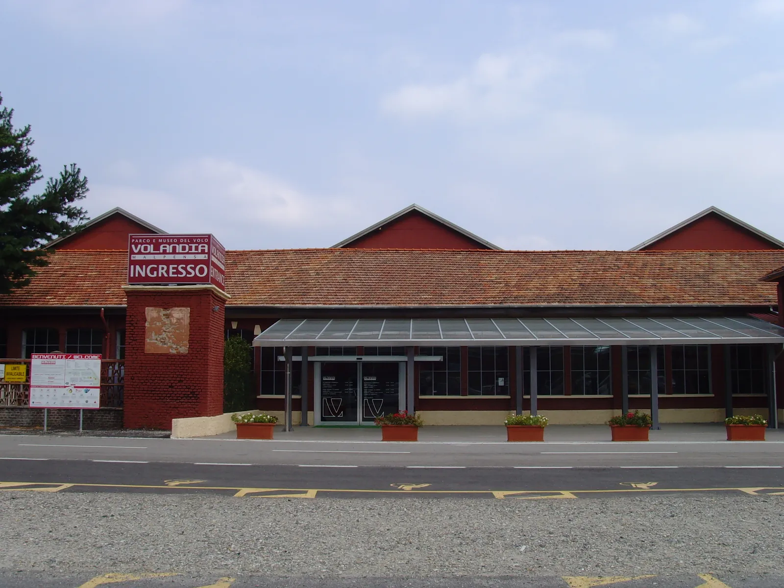 The entrance to Volandia, the museum of flight beside Milan Malpensa airport, in the low brick sheds of the old Caproni aircraft works, with the Volandia sign on a brick pillar