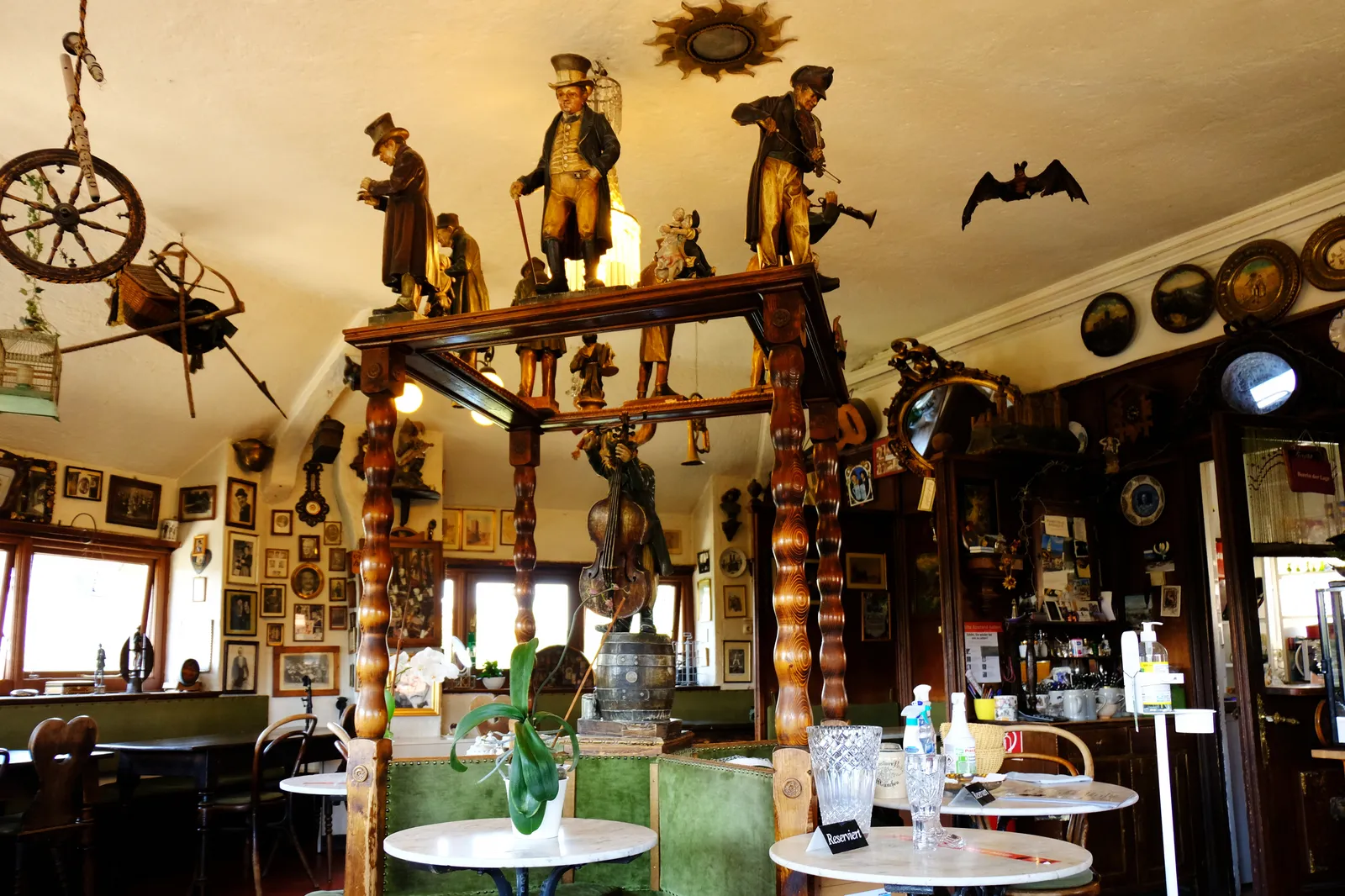 The cluttered, memorabilia-covered interior of the Turmstüberl cafe at the top of Munich's Isartor tower, with carved wooden figures, old photographs and curiosities filling every wall and shelf