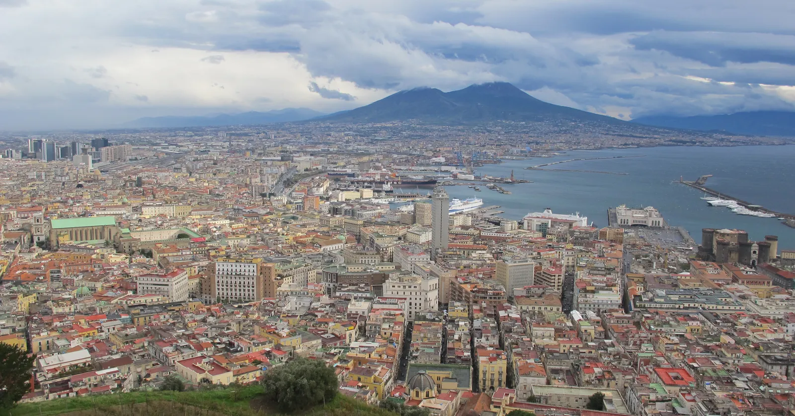 The view north-east from the loggia of the Certosa di San Martino over the rooftops of central Naples, with the port, the bay and the double summit of Vesuvius under heavy cloud