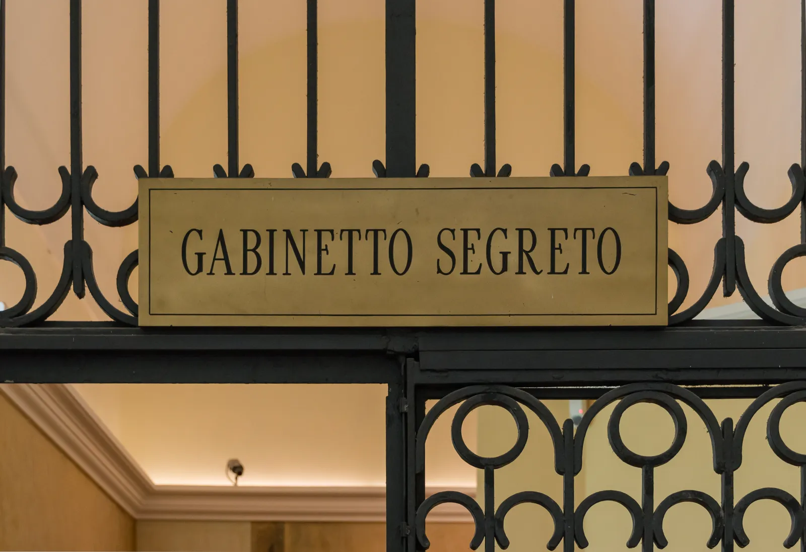 A brass plate reading Gabinetto Segreto fixed to the black ironwork gate at the entrance to the Secret Cabinet in the Naples archaeological museum