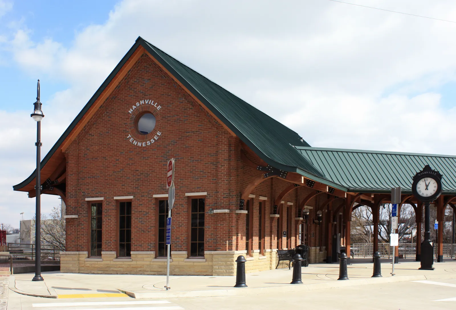 The brick depot building at Riverfront Station in Nashville, with a green gabled roof, a round window lettered Nashville Tennessee, and a platform canopy running off to the right