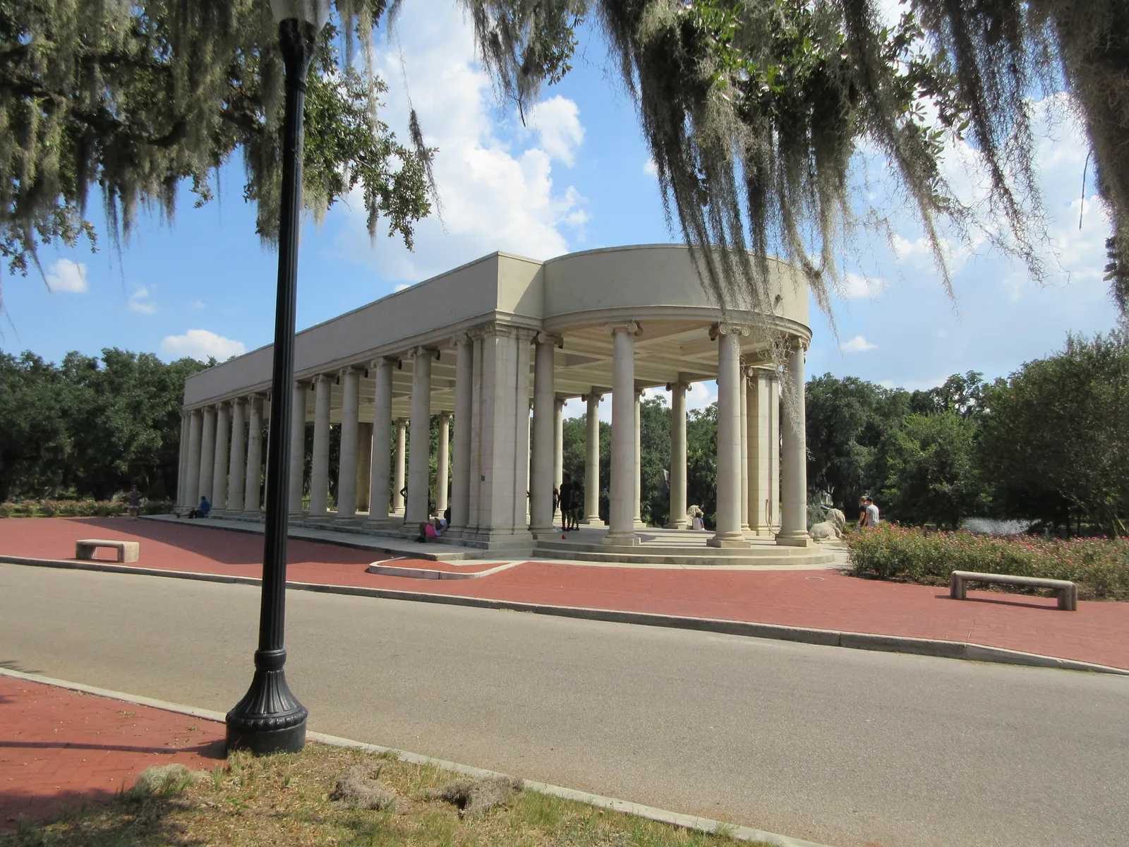 The Peristyle in New Orleans City Park, a long open colonnade of Ionic columns on a raised platform, framed by live oak branches hung with Spanish moss