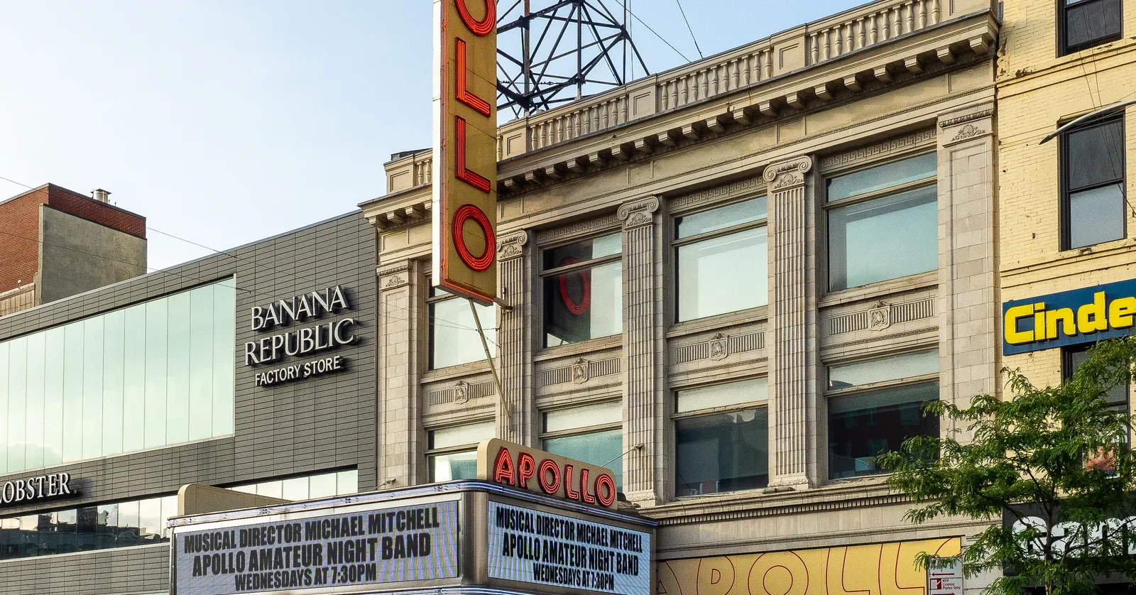 The Apollo Theater on 125th Street, its red vertical APOLLO sign down the front of the building and the marquee below advertising Amateur Night
