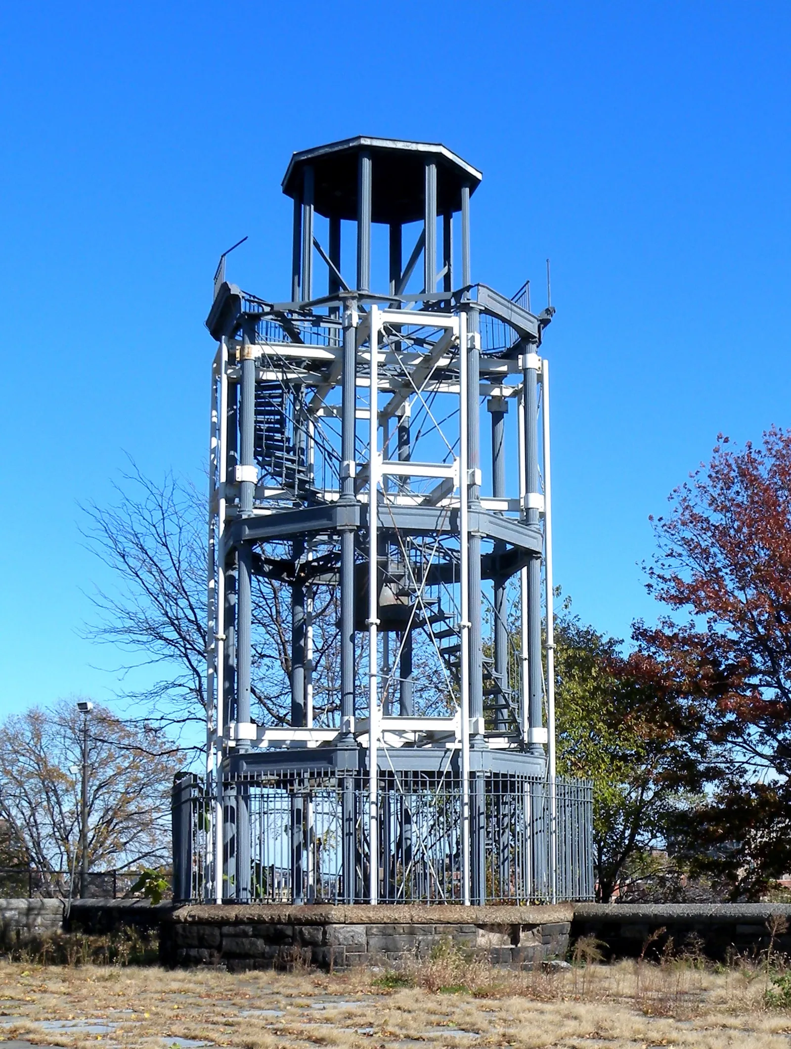 The Mount Morris fire watchtower in Marcus Garvey Park, an open cast iron frame three storeys high with a spiral stair inside it and a bell deck on top