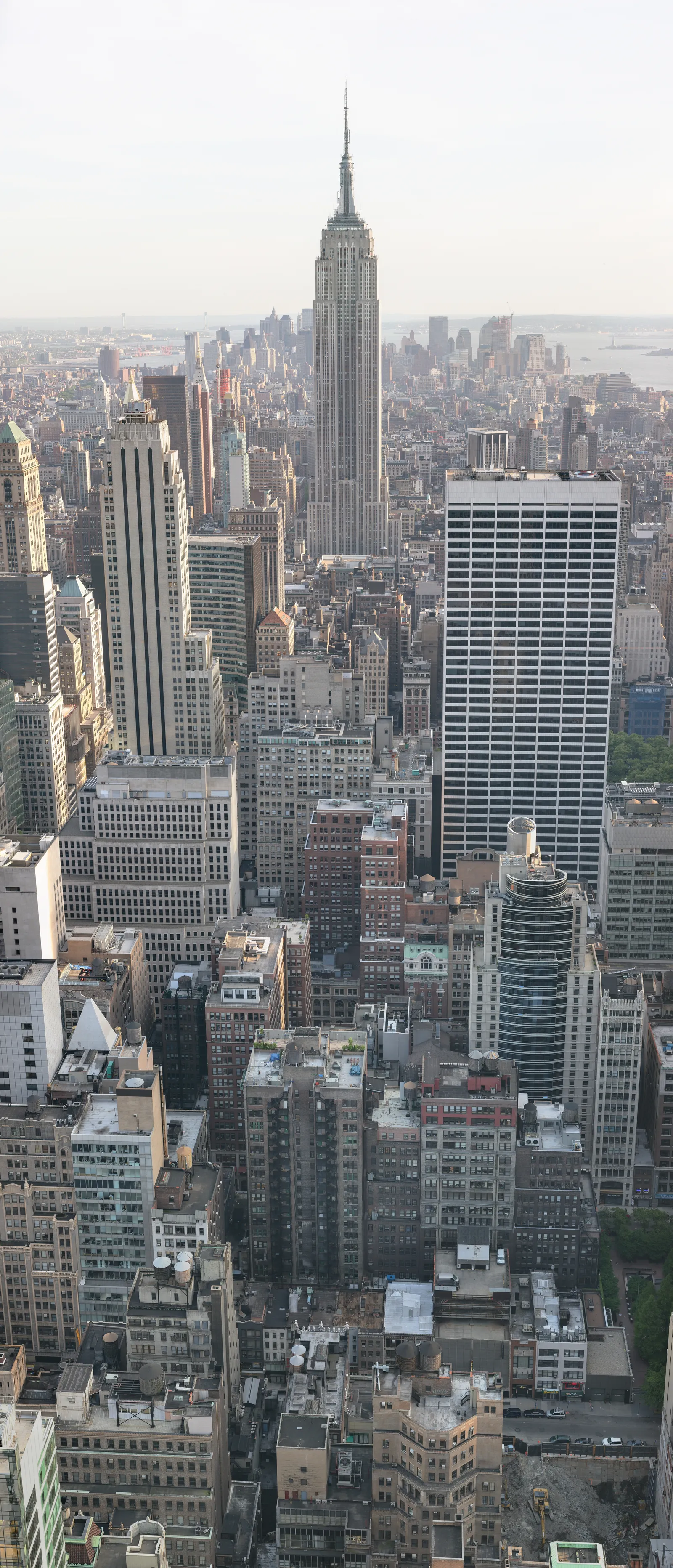 The Empire State Building standing above the surrounding Midtown Manhattan blocks, its setback tower and mast rising well clear of every roof around it