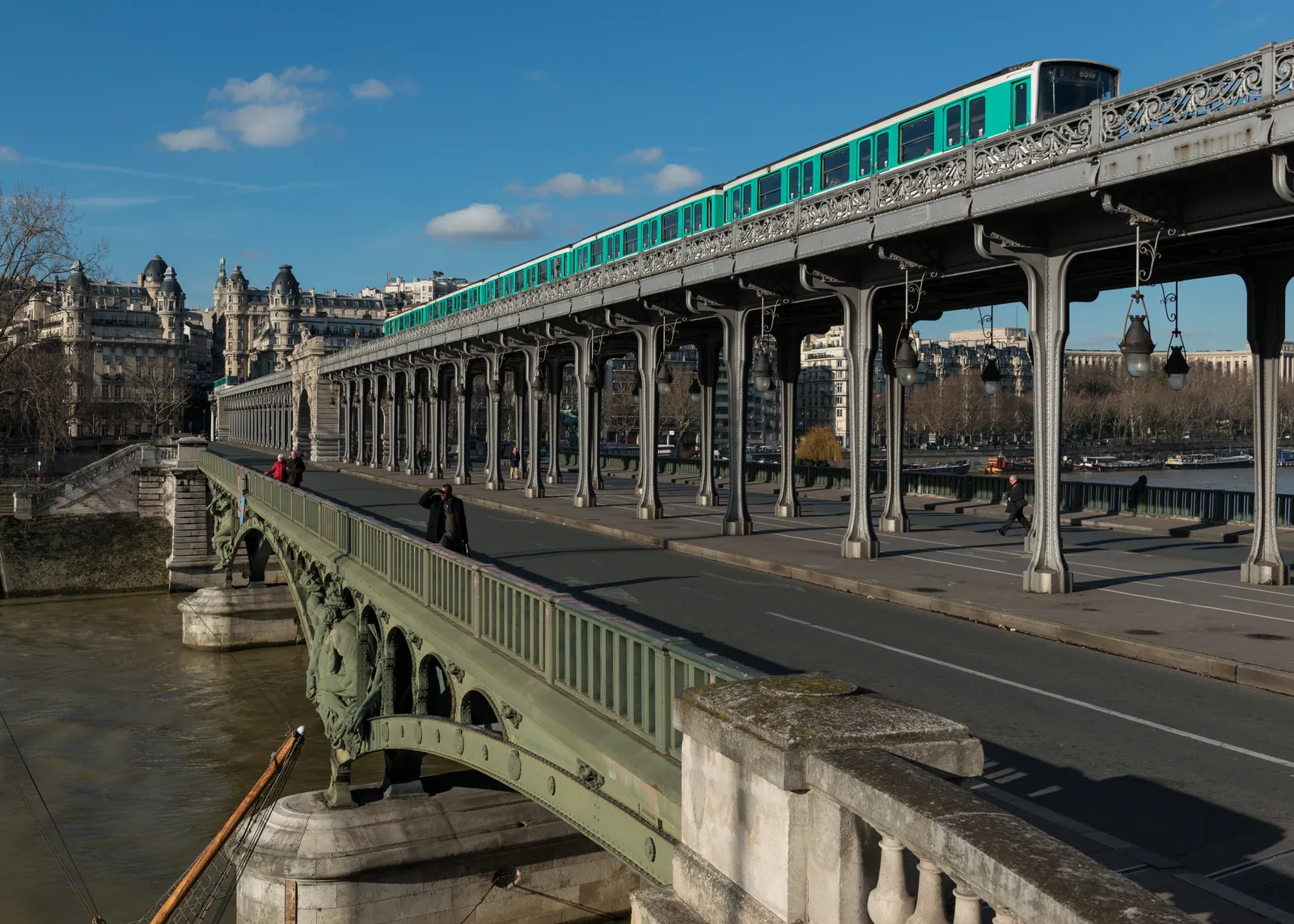 The Pont de Bir-Hakeim in Paris, a metro train running along the upper viaduct on its row of steel columns with the road and pavement deck open below it