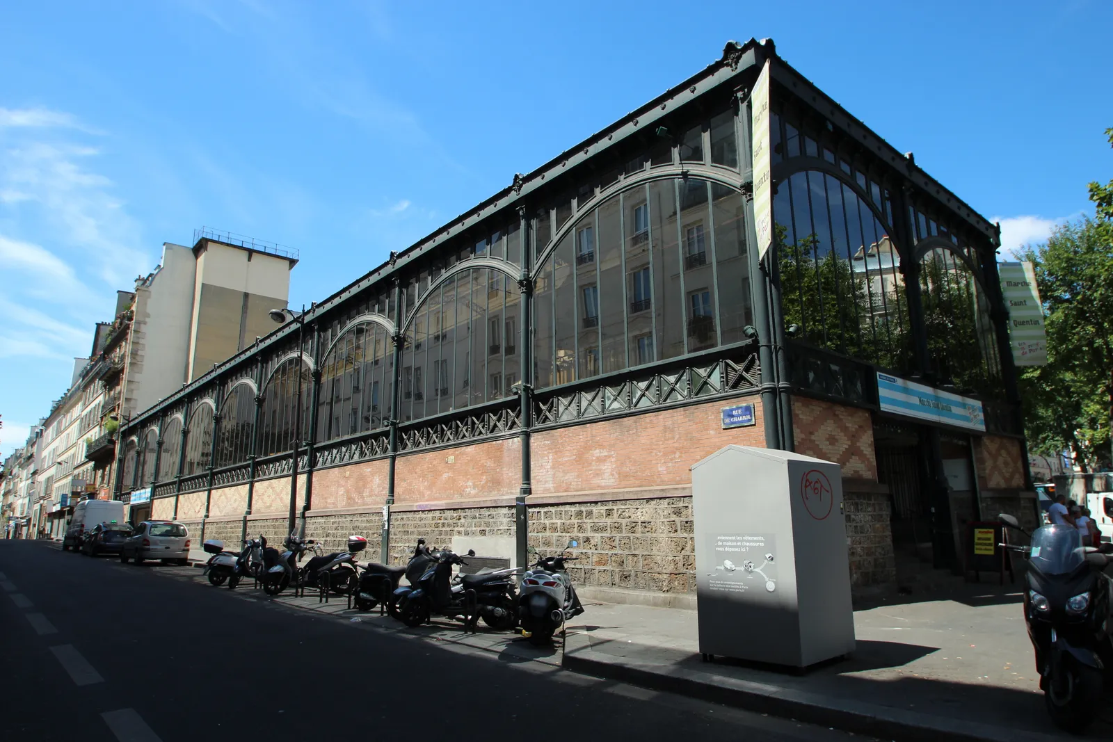 The long iron-and-glass side of the Marché Saint-Quentin covered market on the Boulevard de Magenta in Paris, its arched windows running the full length of the block