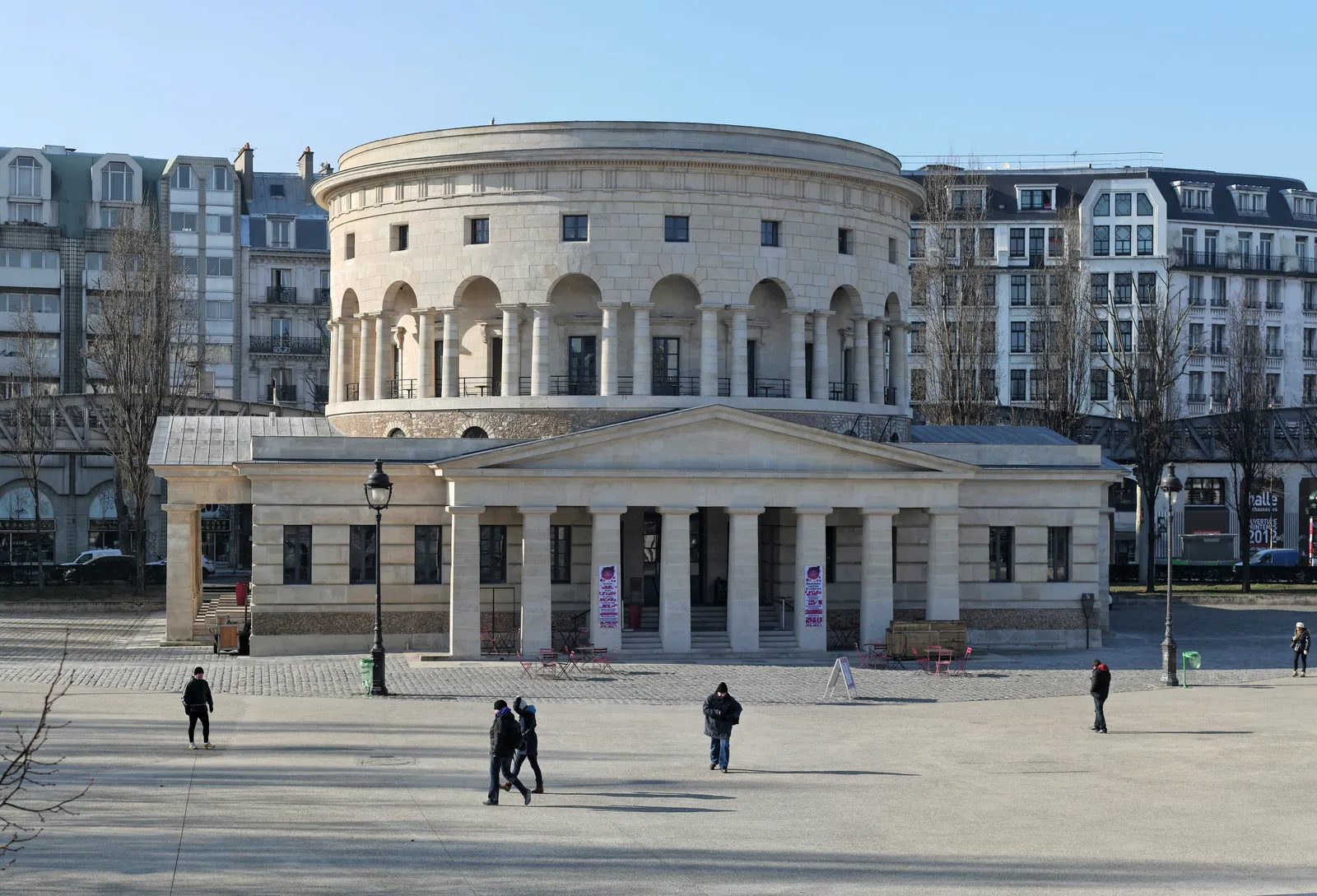 The Rotonde de la Villette in Paris, a neoclassical drum of stone above a colonnaded portico, standing alone on the open paving of the Place de la Bataille-de-Stalingrad