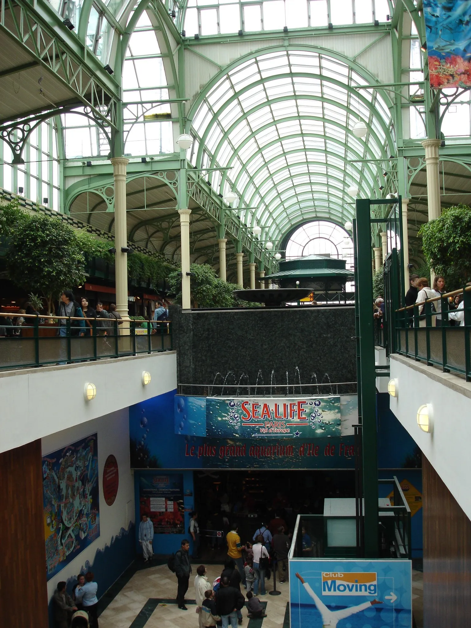The Sea Life aquarium entrance at the Val d'Europe shopping centre, set below a balustraded upper gallery under a barrel-vaulted roof of glass and painted ironwork