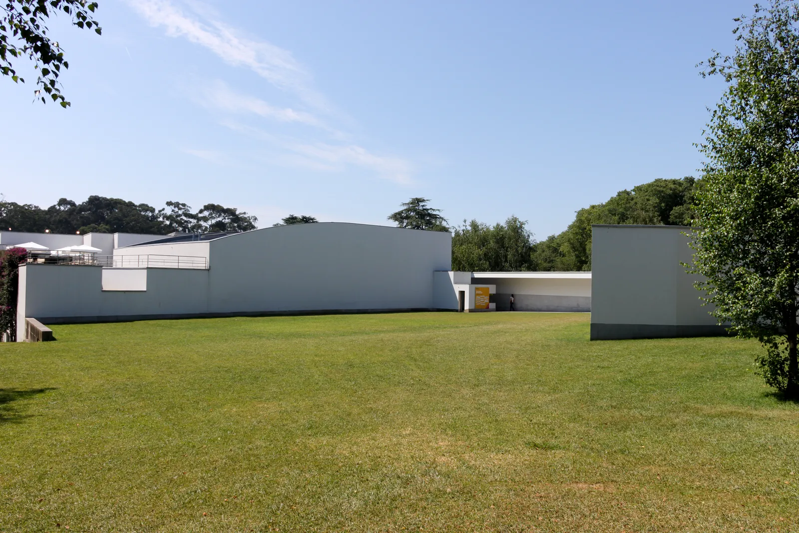 The low white walls of Álvaro Siza's Serralves Museum of Contemporary Art in Porto, set behind a wide lawn and tall trees