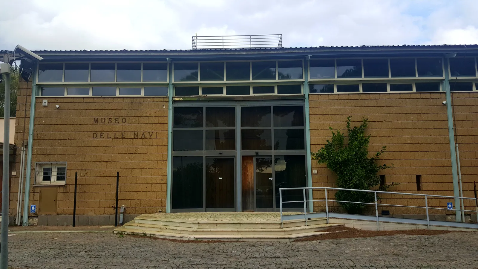 The low brick and glass front of the Museo delle Navi, the Roman ships museum beside Rome's Fiumicino airport, with its name lettered on the wall