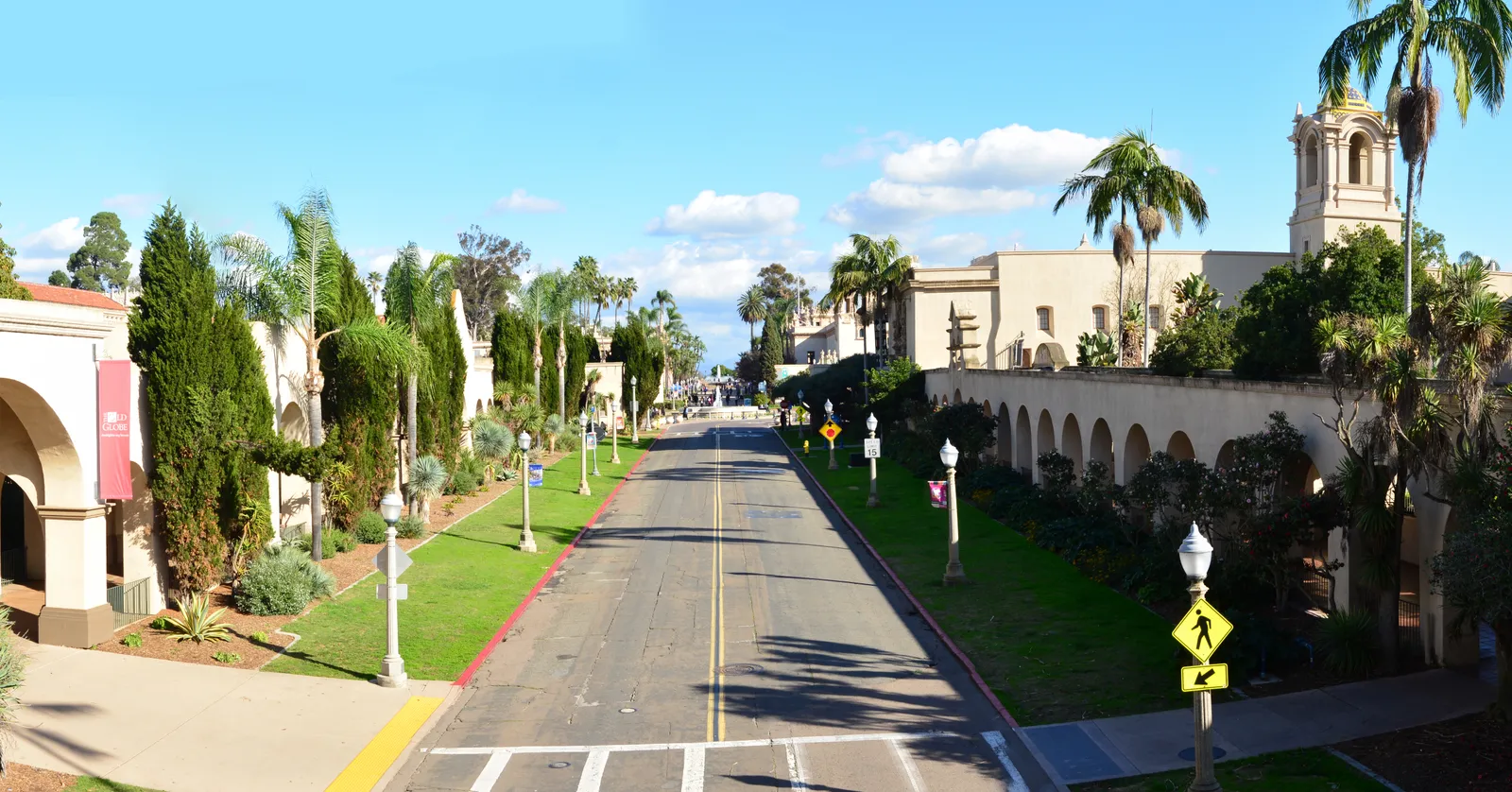 El Prado in Balboa Park, San Diego, running between Spanish Colonial Revival museum buildings with palms along the verges and the California Tower rising on the right