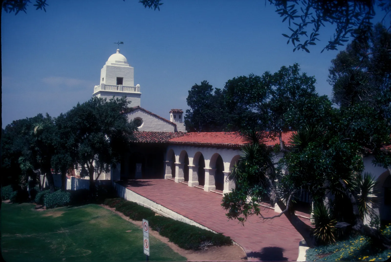 The white tower and red-tiled arcade of the Junipero Serra Museum standing above lawns on Presidio Hill in San Diego