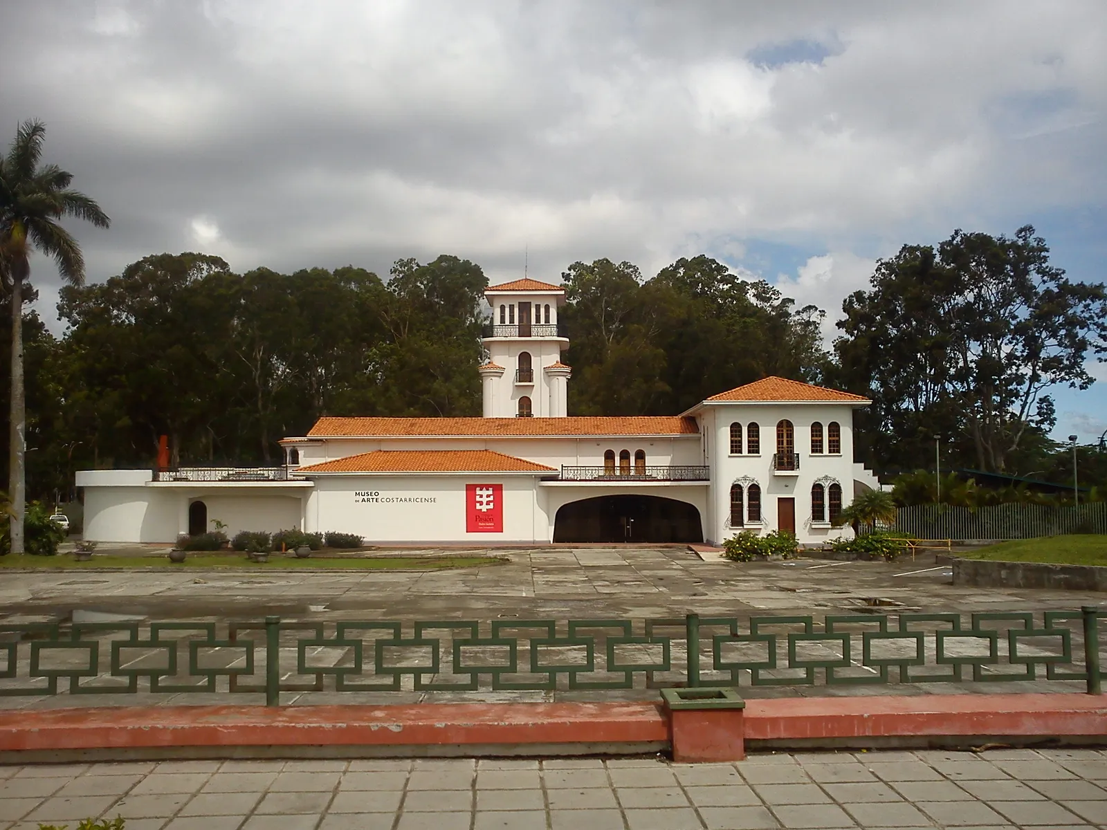 The white former airport terminal in Parque La Sabana, now the Costa Rican art museum, with terracotta roof tiles, arched upper windows and a square control tower rising over the middle