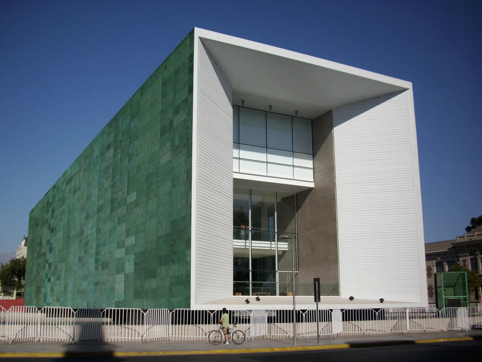 The Museum of Memory and Human Rights in Santiago, a long box clad in oxidised green copper resting inside a white concrete frame, seen from the street