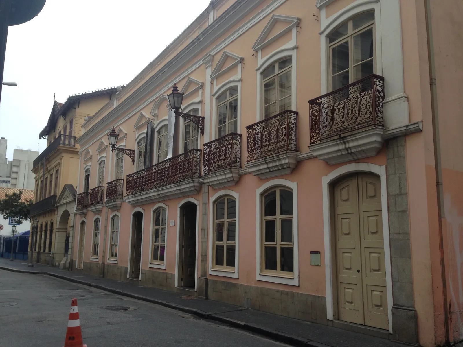 The pink stucco facade of the Solar da Marquesa de Santos in central São Paulo, a long two-storey townhouse with wrought-iron balconies along its upper windows and tall panelled doors at street level