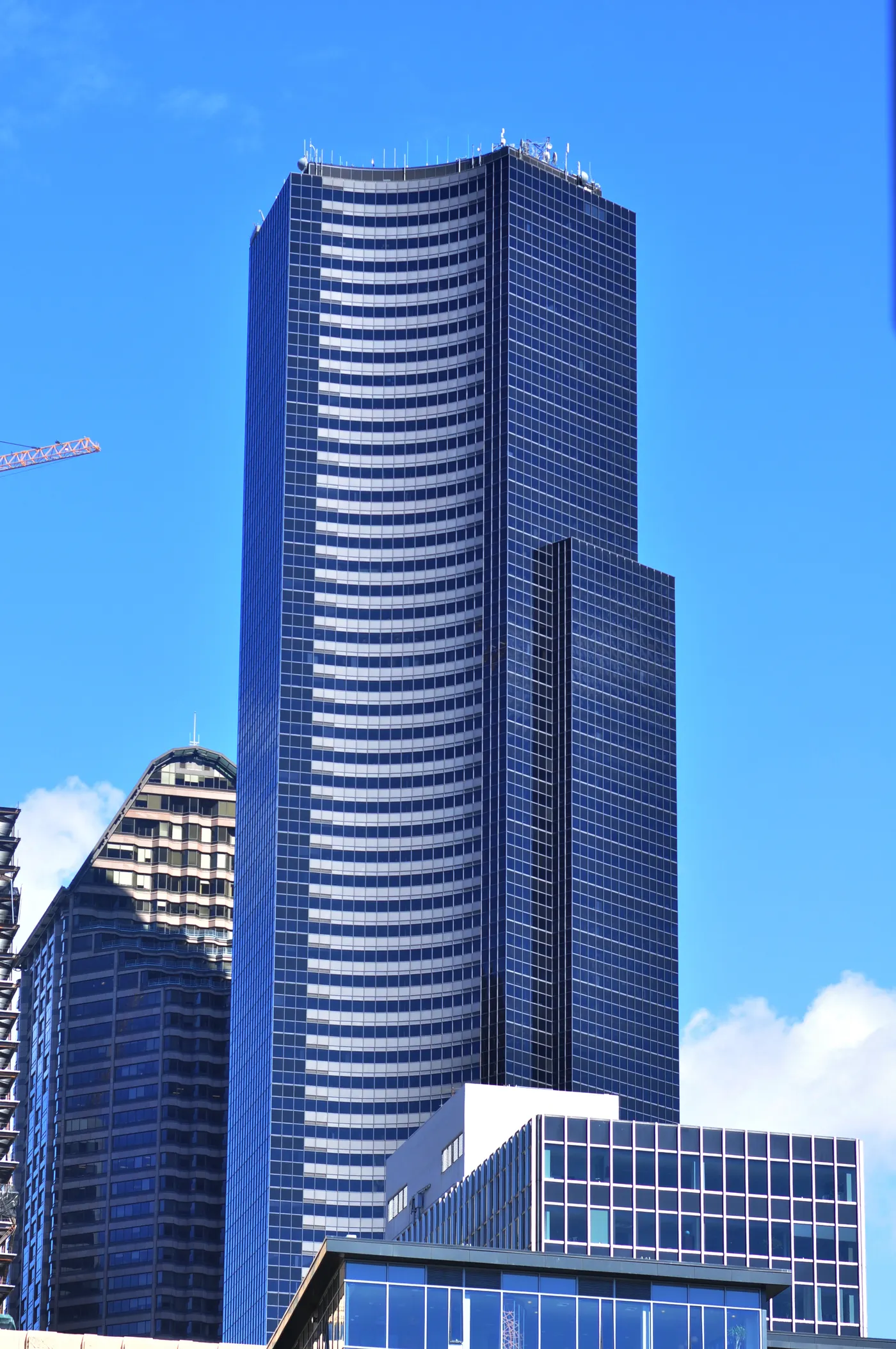 The dark curved glass slab of Columbia Center rising over downtown Seattle against a clear sky, the tallest tower in the skyline