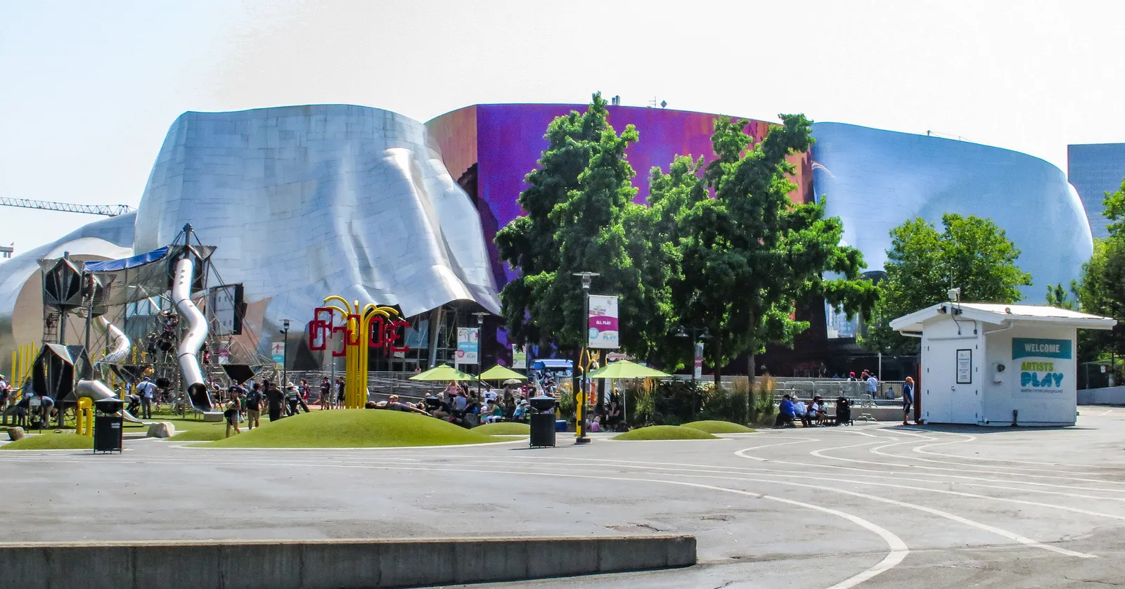 The Museum of Pop Culture at Seattle Center, Frank Gehry's curved building in sheets of silver, purple and blue metal, seen across an open plaza