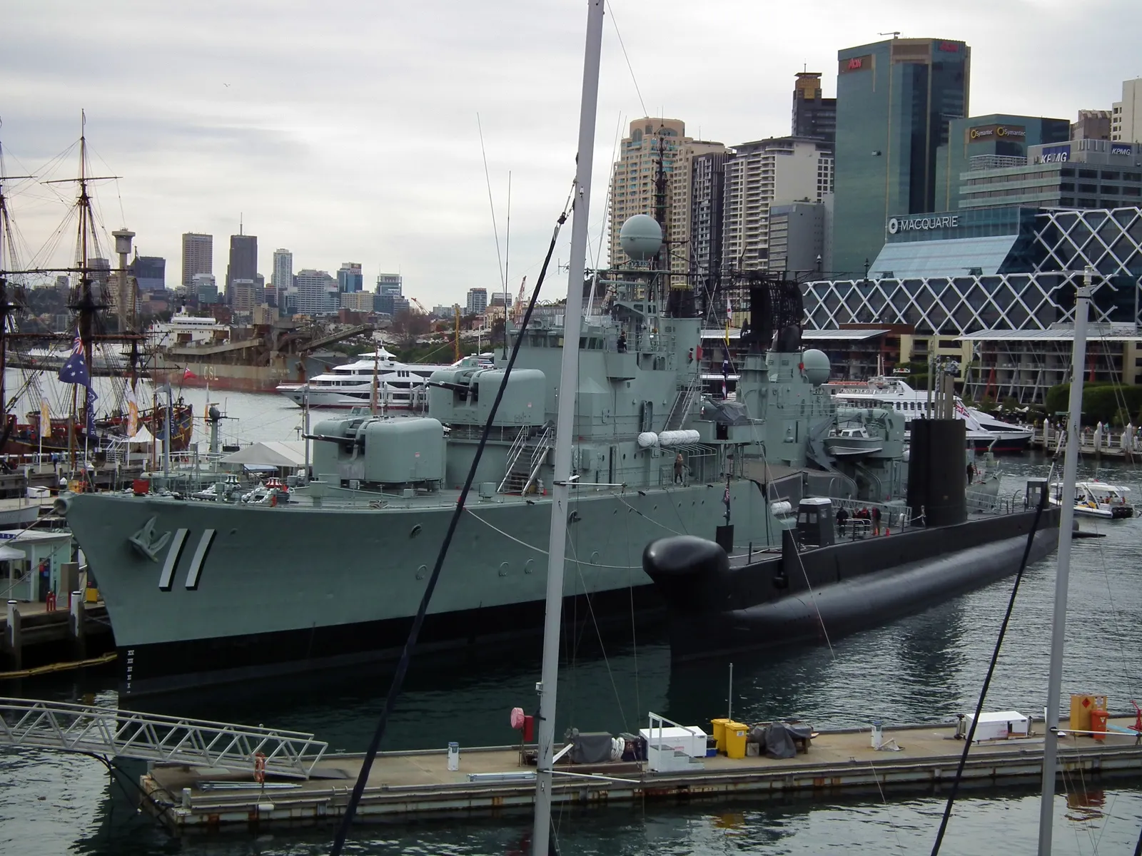 The grey destroyer HMAS Vampire, hull number 11, moored at the Australian National Maritime Museum in Darling Harbour, with the black submarine HMAS Onslow alongside