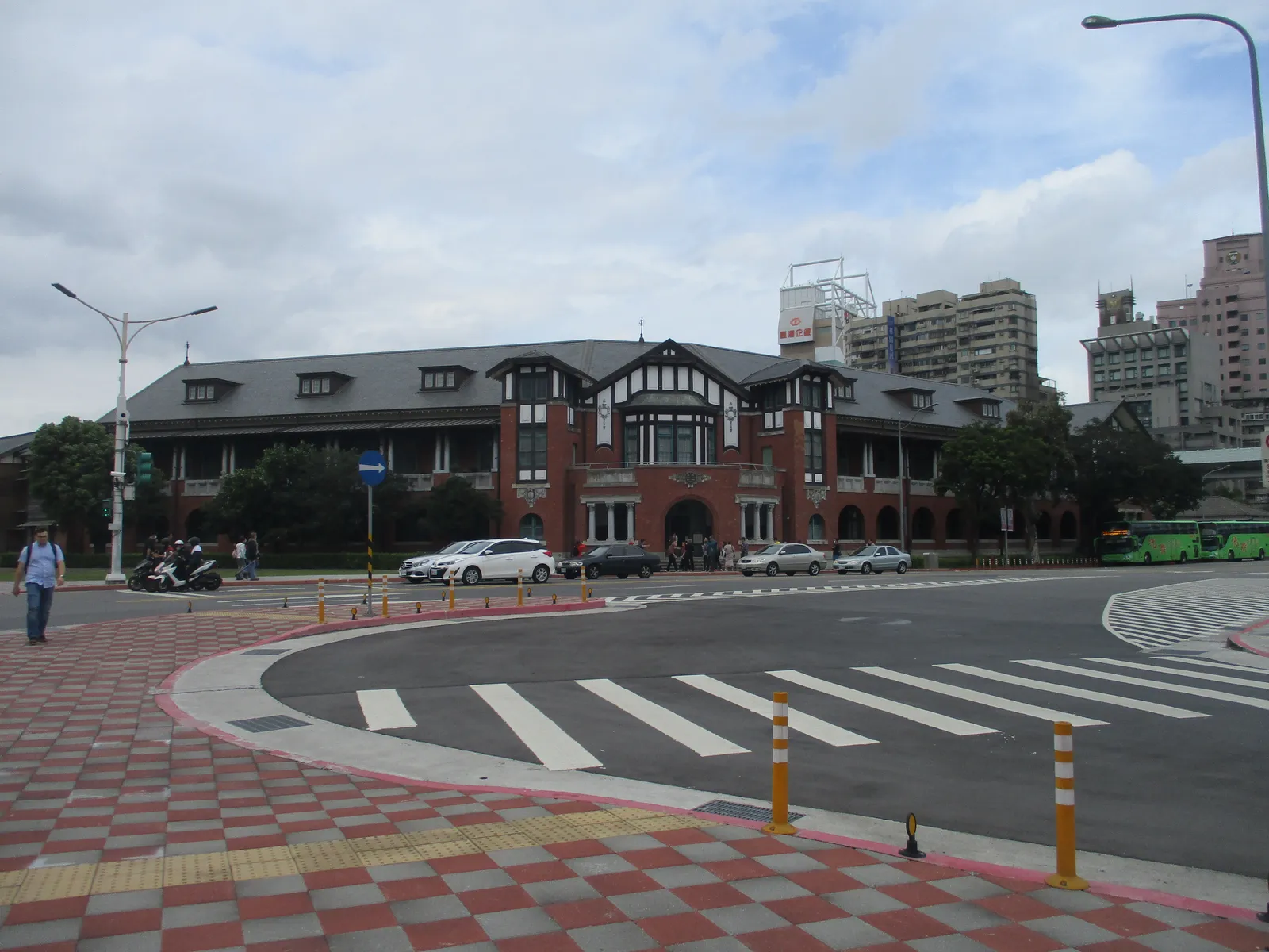 The red brick and timber Railway Department building of 1918 in Taipei, with a steep dark roof and arched ground-floor windows, seen from the street corner
