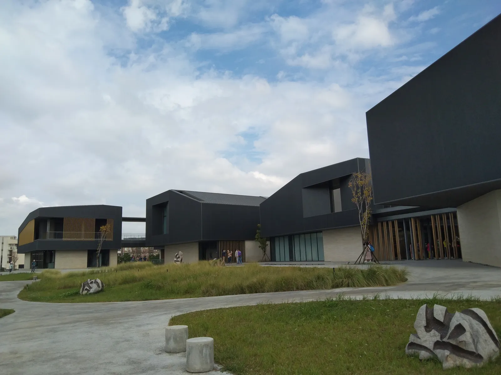 The dark angular blocks of the Hengshan Calligraphy Art Center in Taoyuan, standing in a landscaped park of grass, low stone sculptures and curving paths
