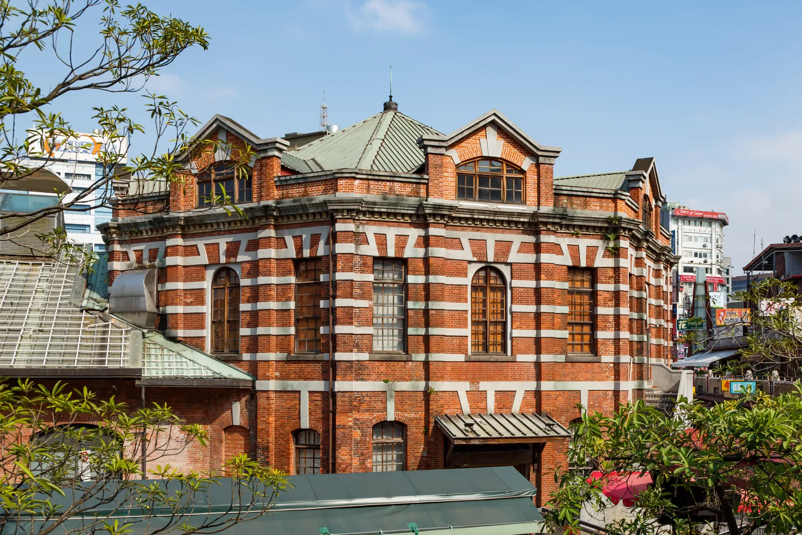 The octagonal Red House in Taipei's Ximending, built of red brick banded with white stone under a dark tiled roof, with arched windows on each of its eight faces