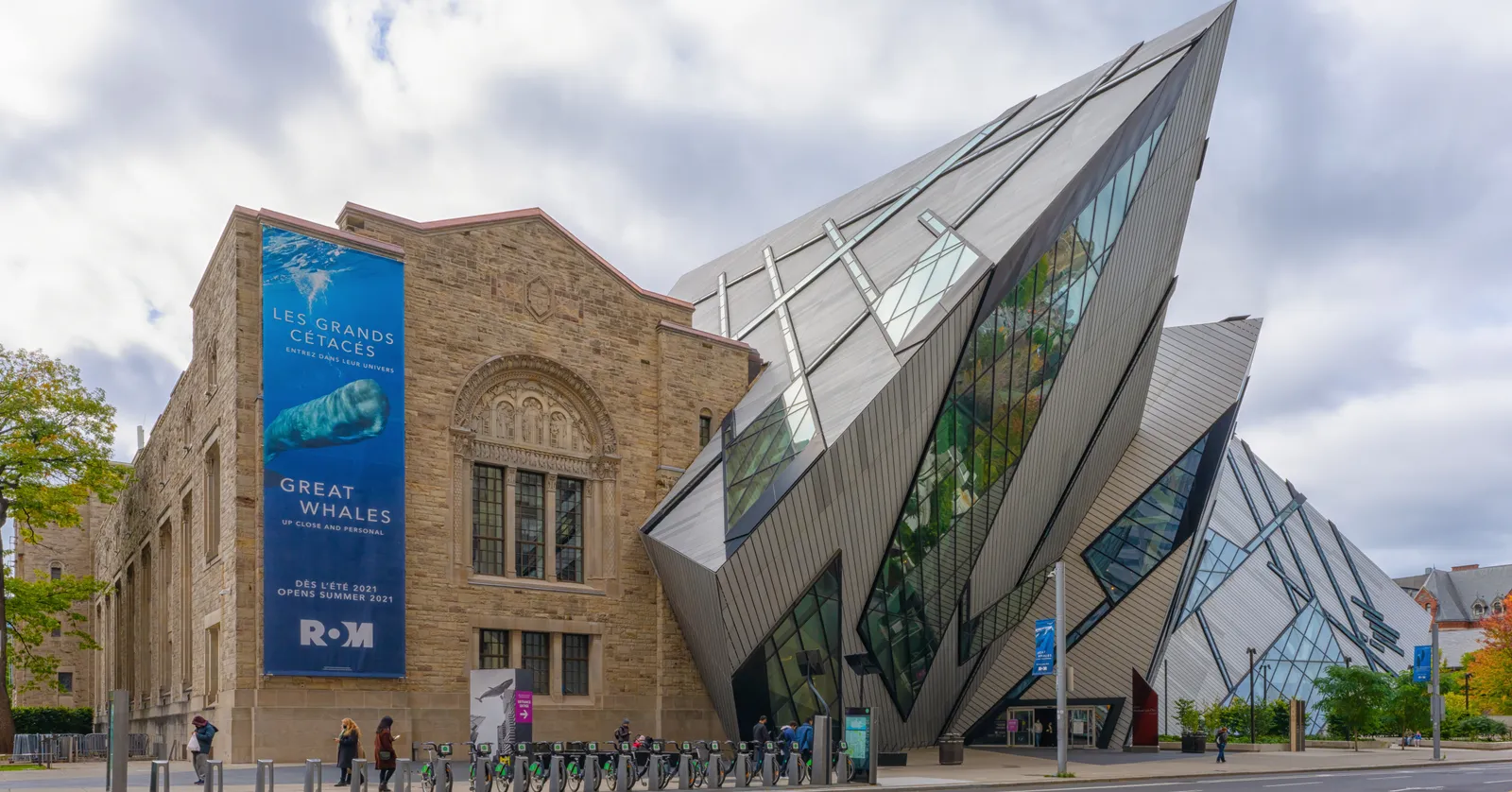 The Royal Ontario Museum in Toronto, with the angular glass and aluminium Michael Lee-Chin Crystal jutting out over the pavement beside the museum's older arched stone wing