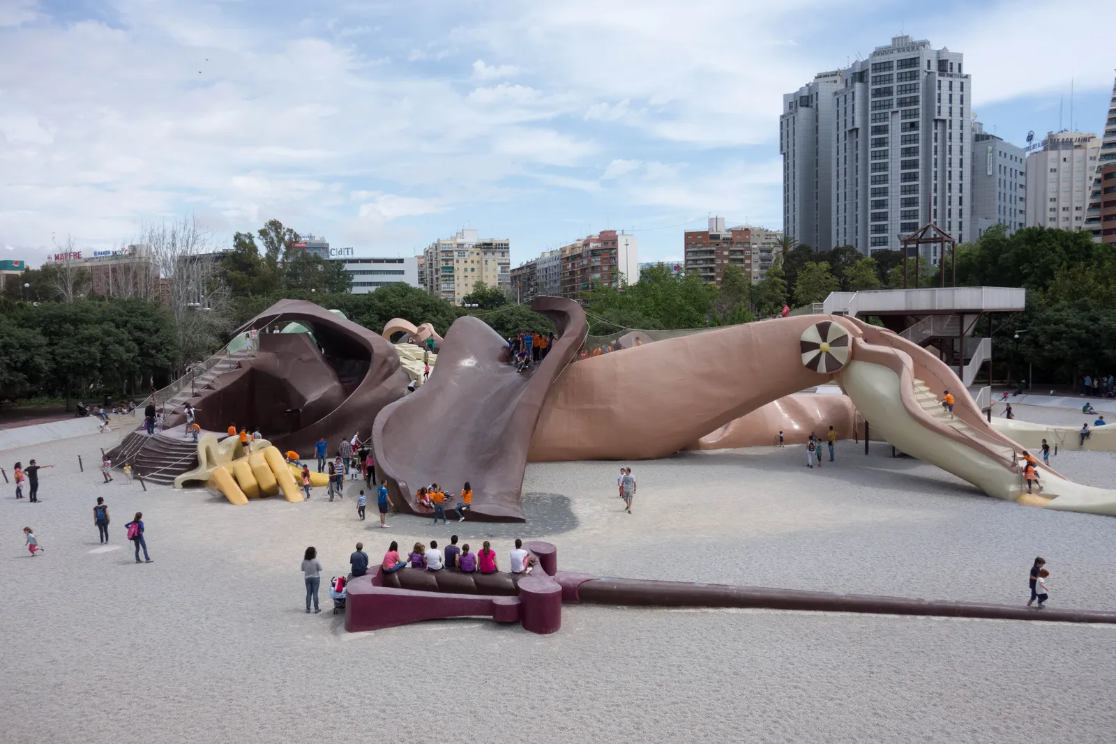 The Gulliver playground in the Turia riverbed in Valencia, a giant reclining figure with slides and steps built into its clothing, with children climbing on it