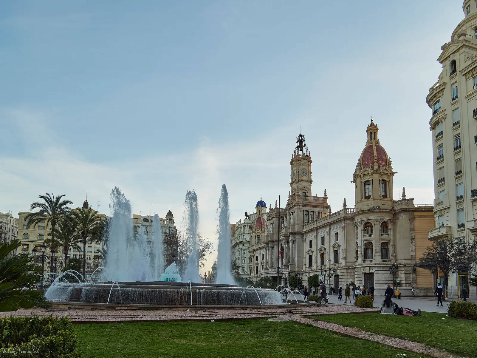 The Plaza del Ayuntamiento in Valencia with its round fountain jets running and the domed city hall behind
