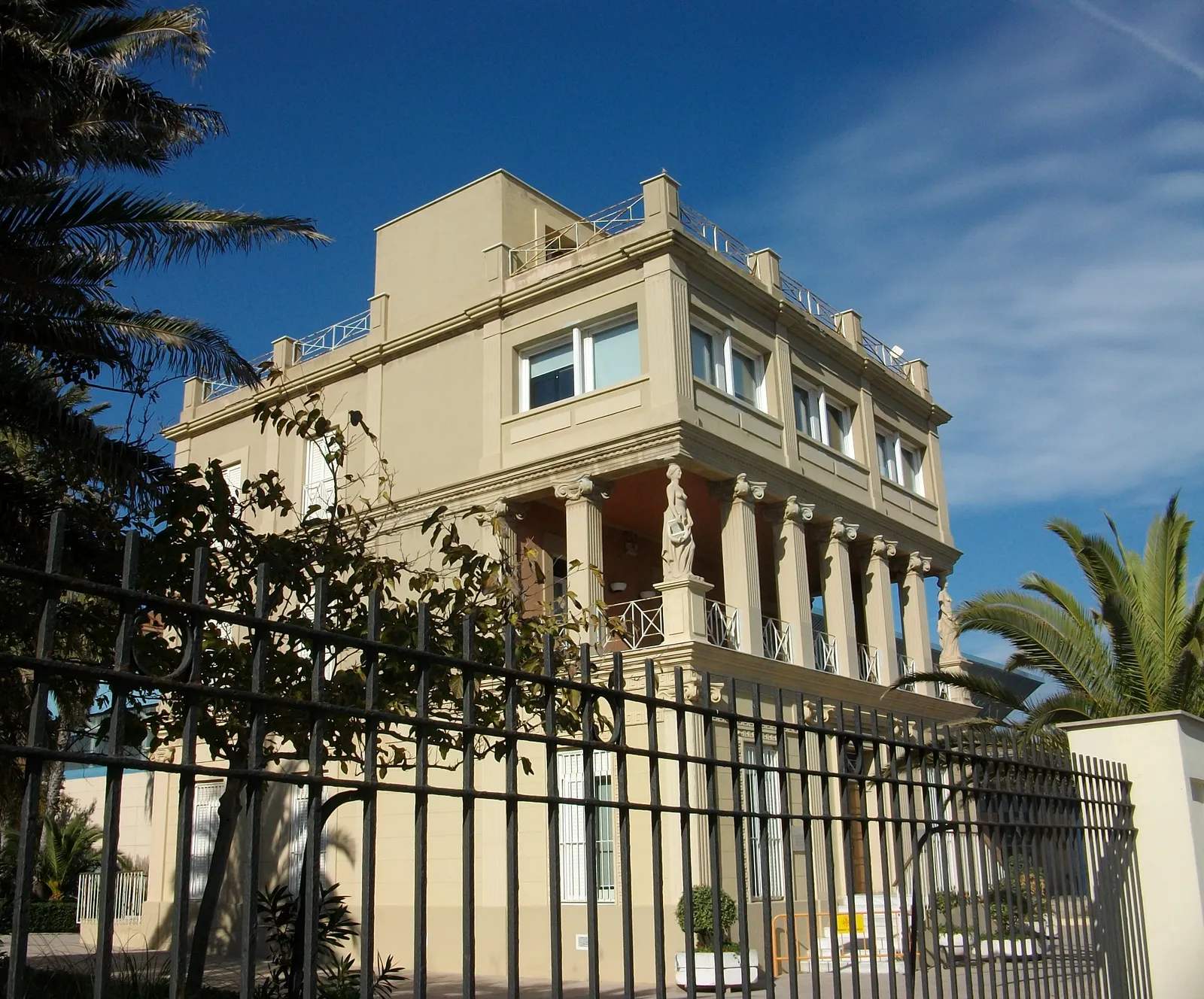 The Blasco Ibáñez house museum behind its railings on the Malvarrosa seafront in Valencia, a cream villa with a columned porch and palms in the garden