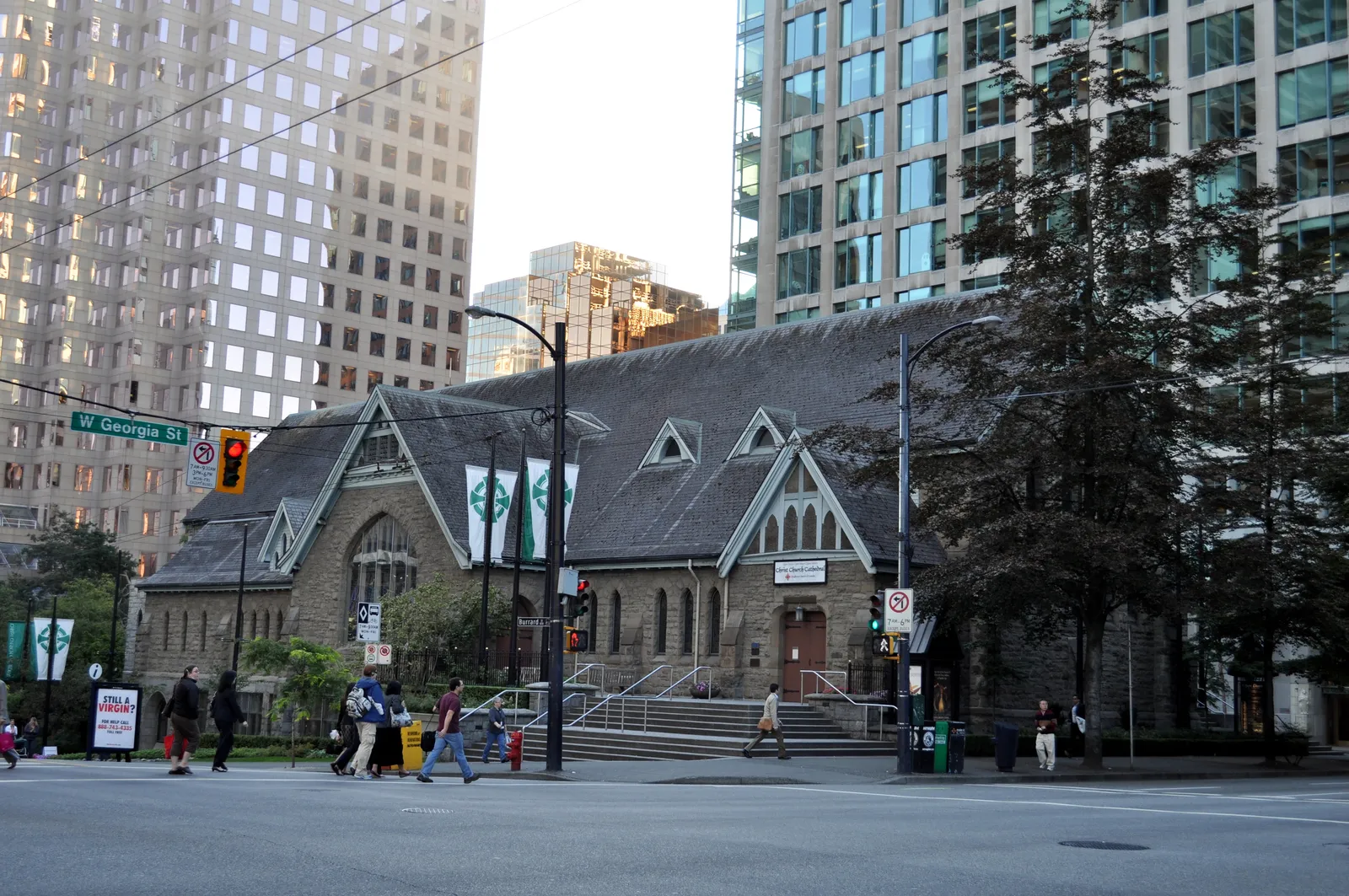 The low grey stone gables of Christ Church Cathedral on the corner of Burrard and Georgia Streets in Vancouver, dwarfed by the glass office towers behind it