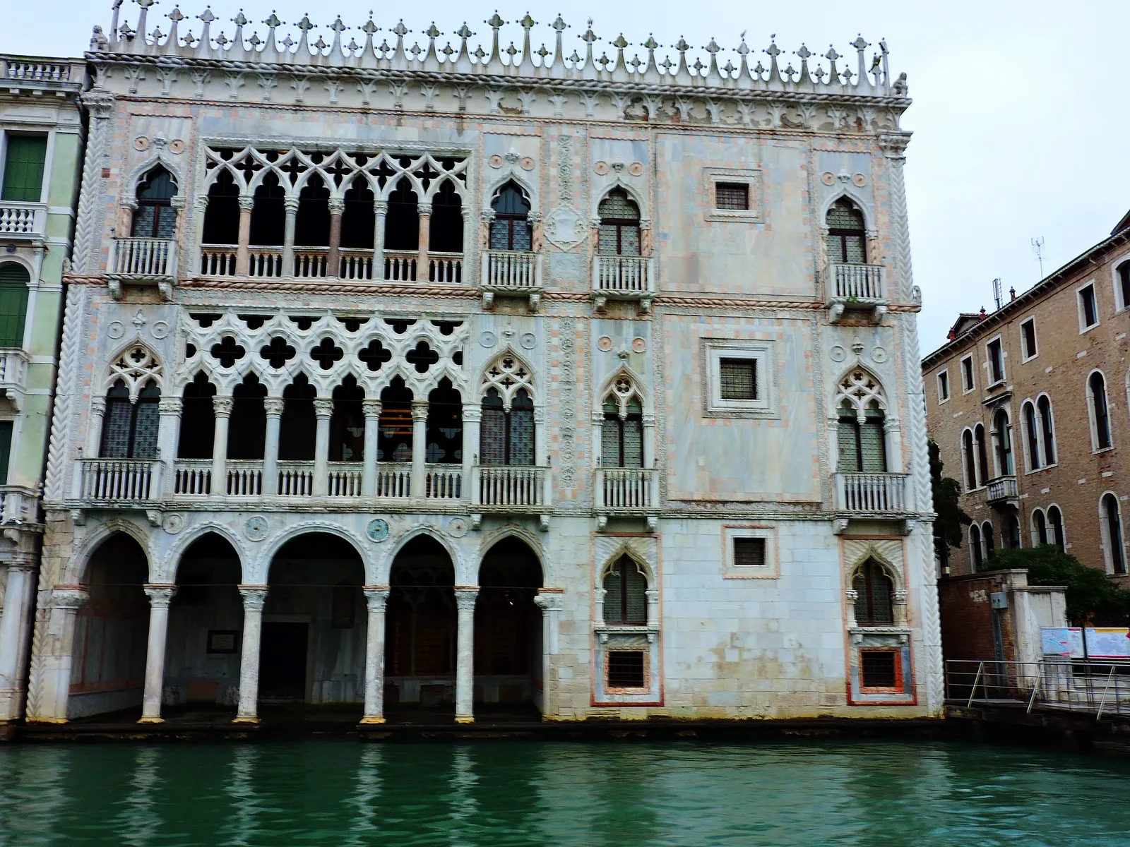The ornate Gothic marble facade of Ca' d'Oro palace rising directly from the Grand Canal in Venice