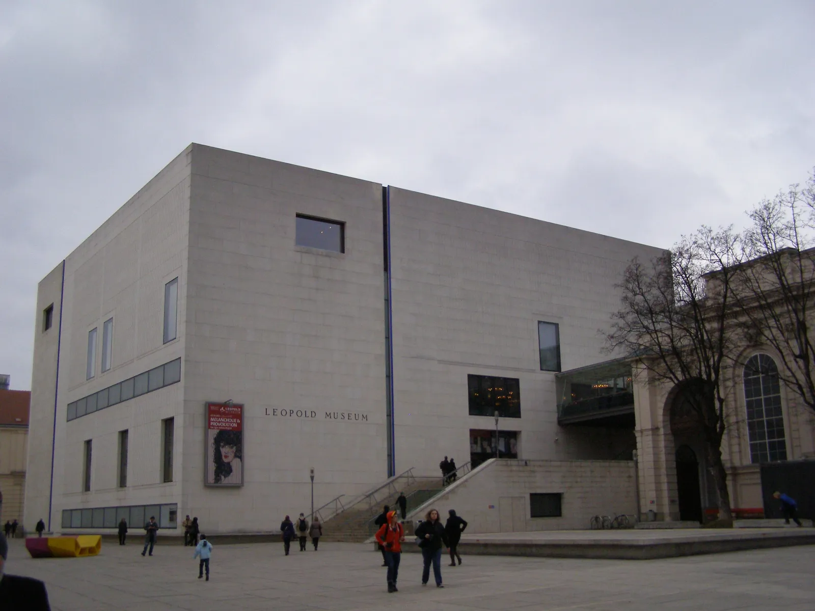 The Leopold Museum in Vienna, a plain pale limestone cube with few windows and its name cut into the stone above the entrance steps, standing in the MuseumsQuartier courtyard