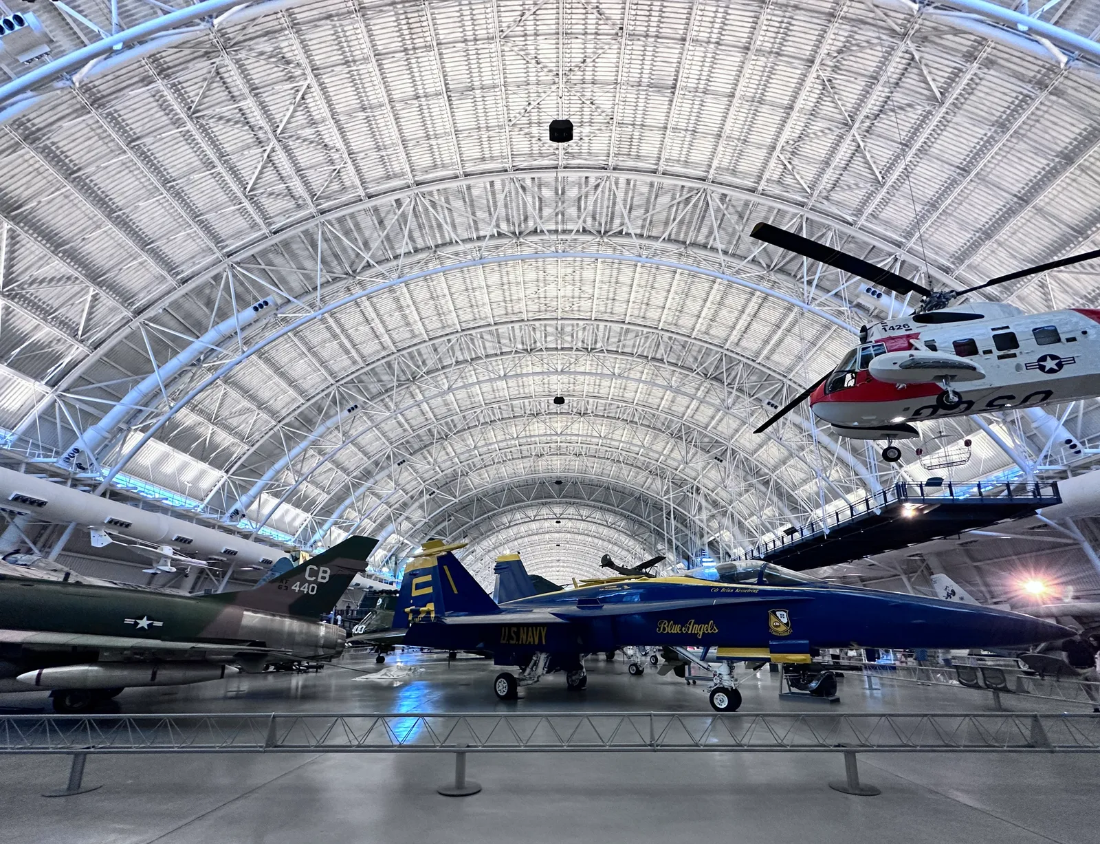 The main aviation hangar at the Udvar-Hazy Center, a vast steel-arched shed with military jets on the floor and helicopters and light aircraft suspended overhead