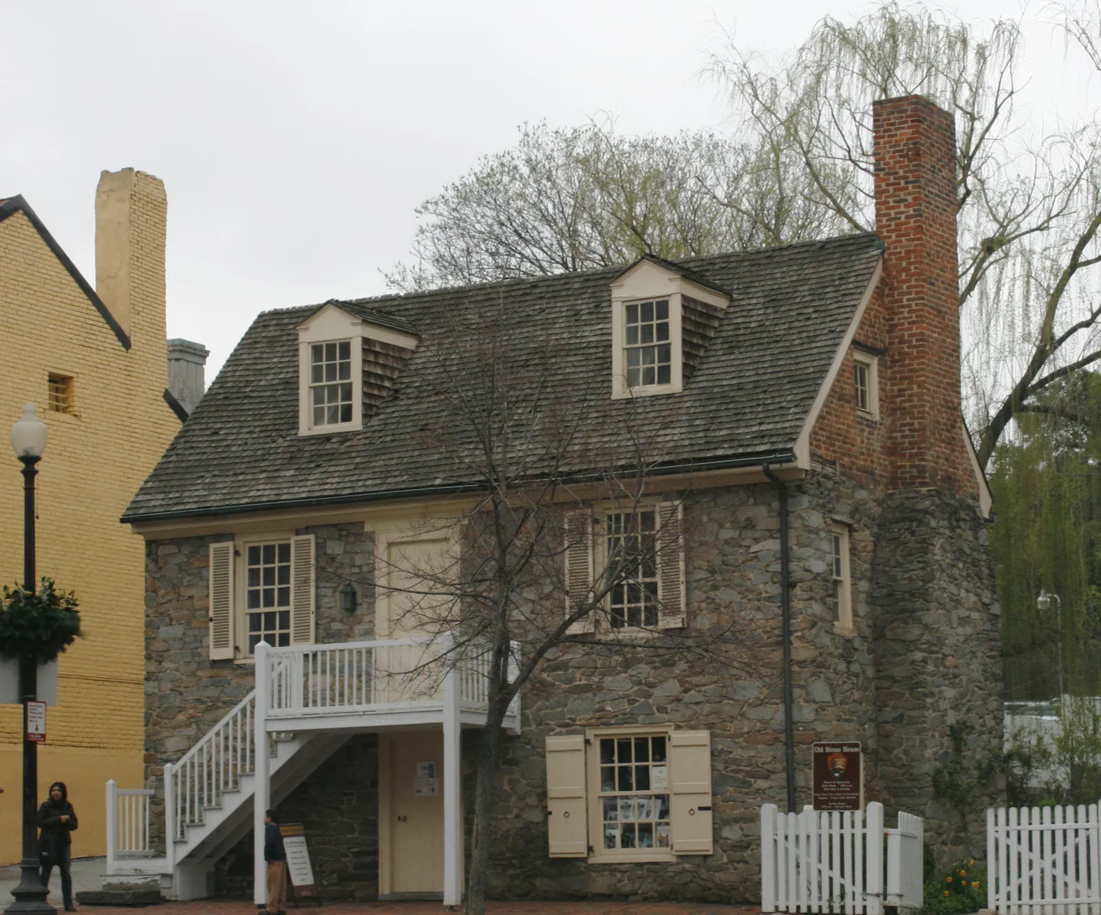 The Old Stone House on M Street in Georgetown, a two-storey fieldstone cottage with dormer windows, a tall brick chimney and a white external staircase