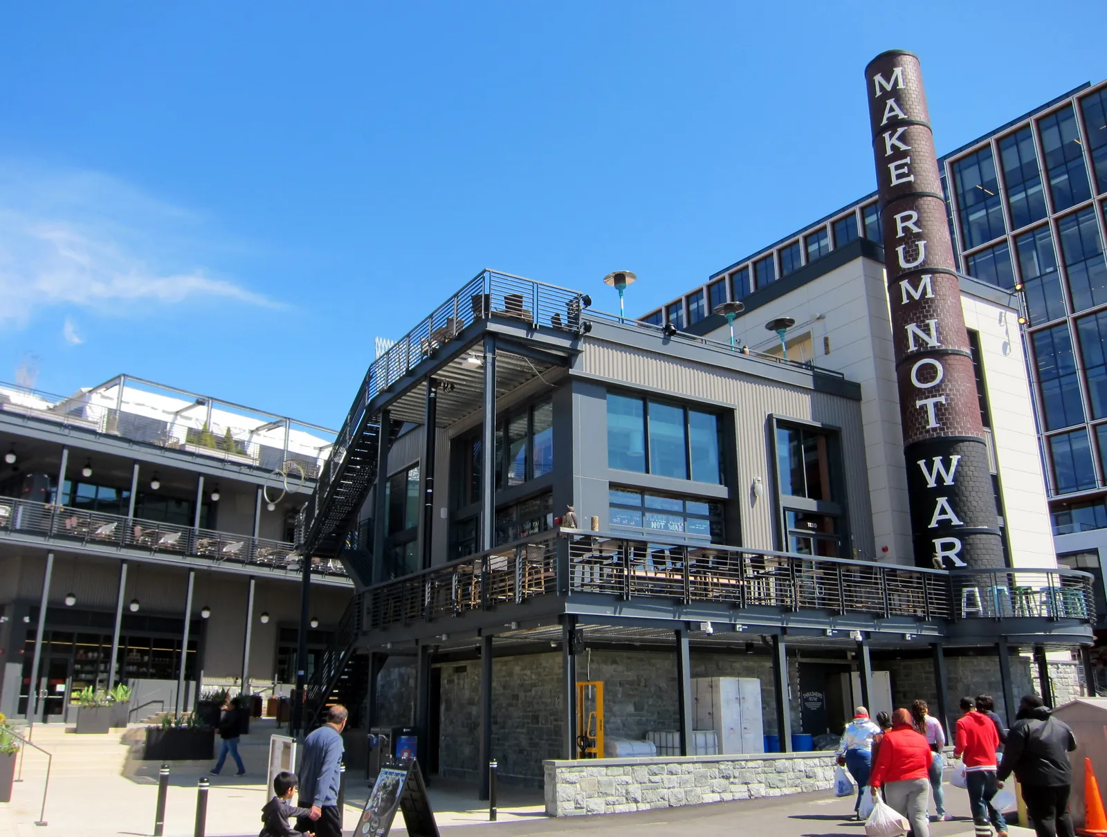 The Wharf development on the Washington Channel, a row of glass and steel waterfront buildings with terraces above a walkway and a tall signboard tower