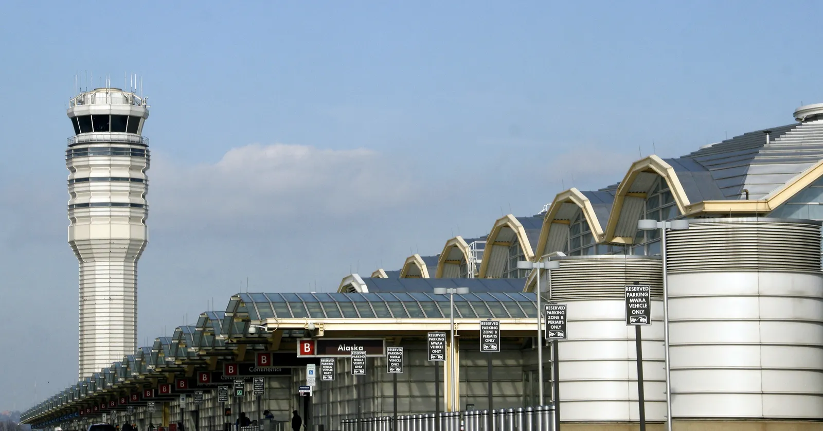 The control tower at Ronald Reagan Washington National Airport standing beside the row of low domed vaults along the roof of the main terminal