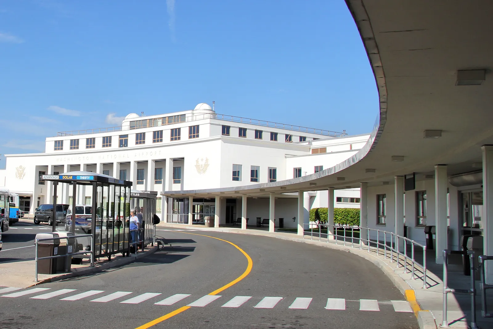 The white streamlined frontage of the 1941 terminal building at Reagan National Airport, with a curved concrete canopy running out over the kerb in front of it