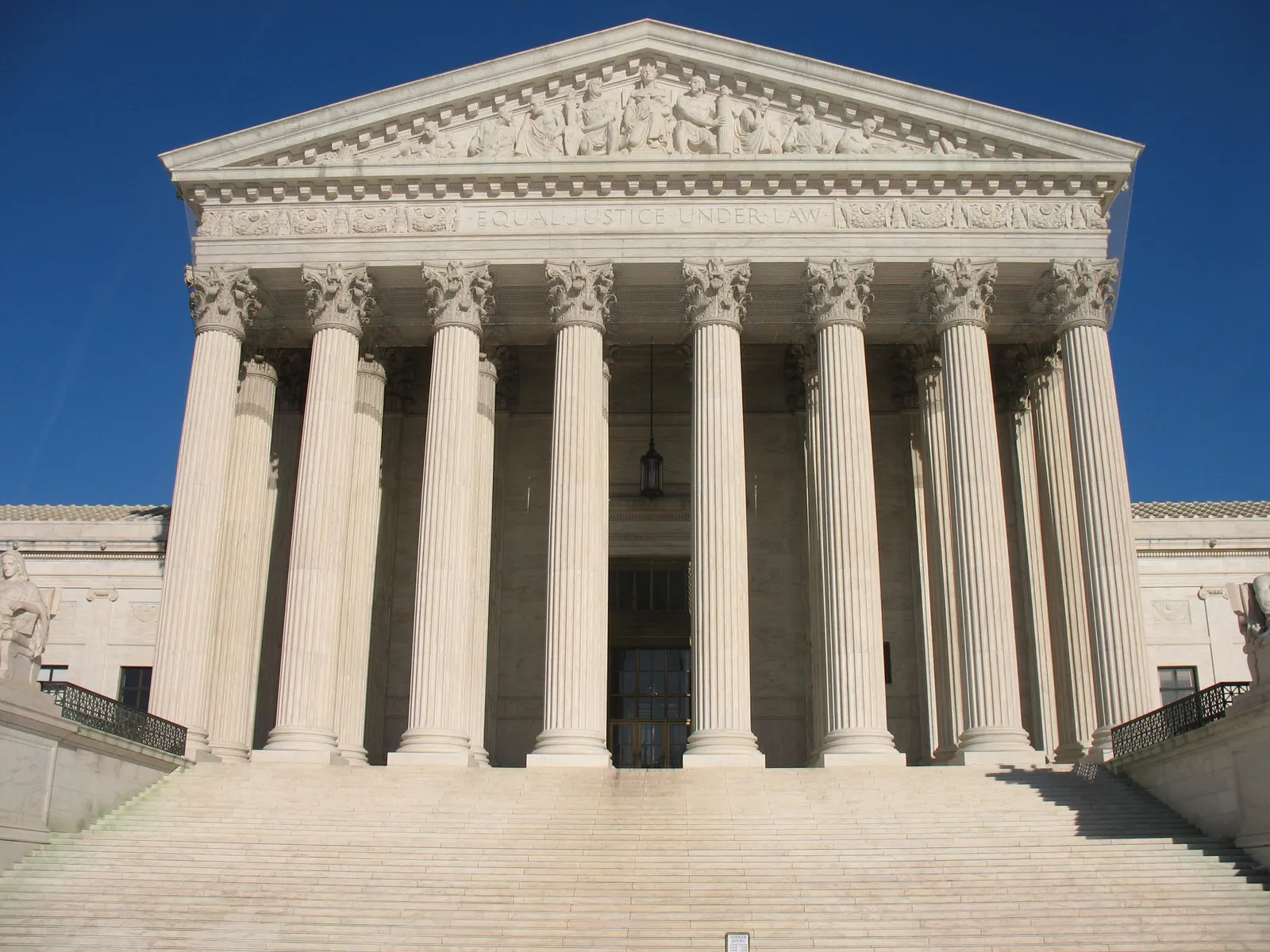 The west front of the Supreme Court building in Washington, a marble portico of Corinthian columns and a carved pediment above a broad flight of steps